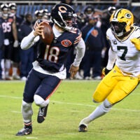 Jan 10, 2026; Chicago, IL, USA; Chicago Bears quarterback Caleb Williams (18) rolls out as Green Bay Packers linebacker Quay Walker (7) applies the pressure during the first half of an NFC Wild Card Round game at Soldier Field.