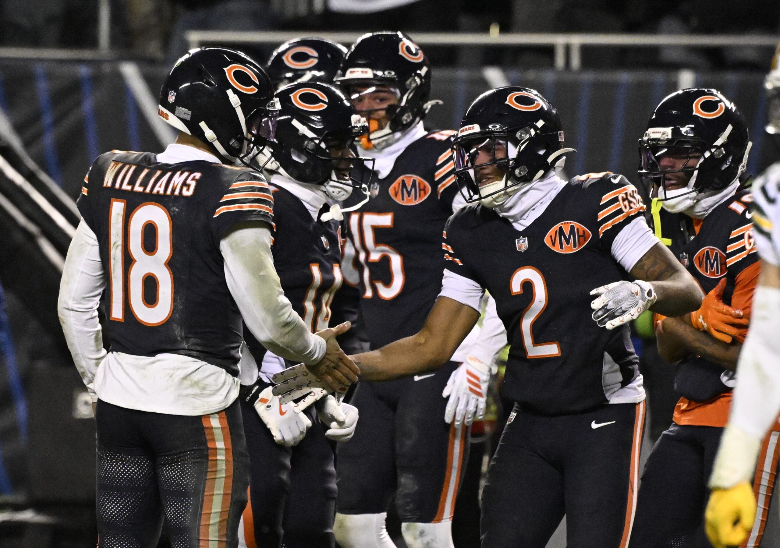 Jan 10, 2026; Chicago, IL, USA; Chicago Bears quarterback Caleb Williams (18) and wide receiver DJ Moore (2) react after hooking up on the eventually game winning touchdown against the Green Bay Packers during the second half of an NFC Wild Card Round game at Soldier Field.