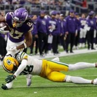 Green Bay Packers Trevon Diggs (28) puts a hit on Minnesota Vikings running back Jordan Mason (27) during their game Sunday, Jan. 4, 2026, at U.S. Bank Stadium in Minneapolis, Minnesota.