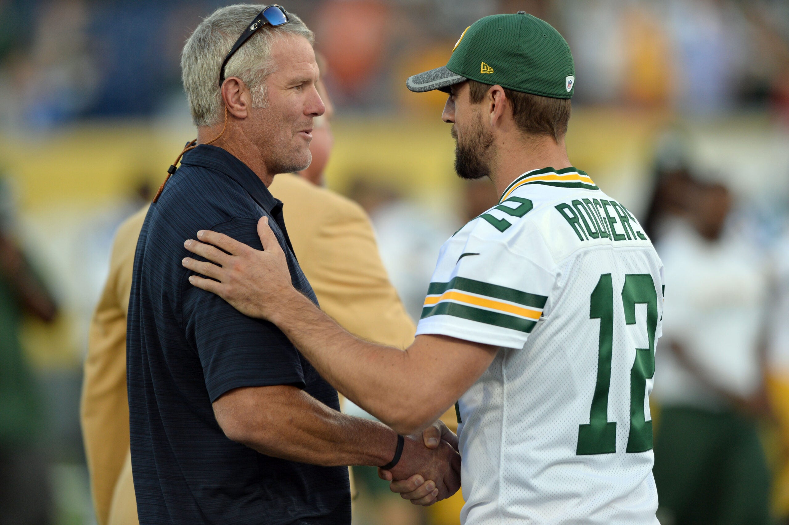 Aug 7, 2016; Canton, OH, USA; Green Bay Packers quarterback Aaron Rodgers (12) greets Hall of Fame member Brett Favre before the game between the Indianapolis Colts and the Green Bay Packers at the 2016 Hall of Fame Game at Tom Benson Hall of Fame Stadium. The game was cancelled due to safety concerns with the condition of the playing surface.