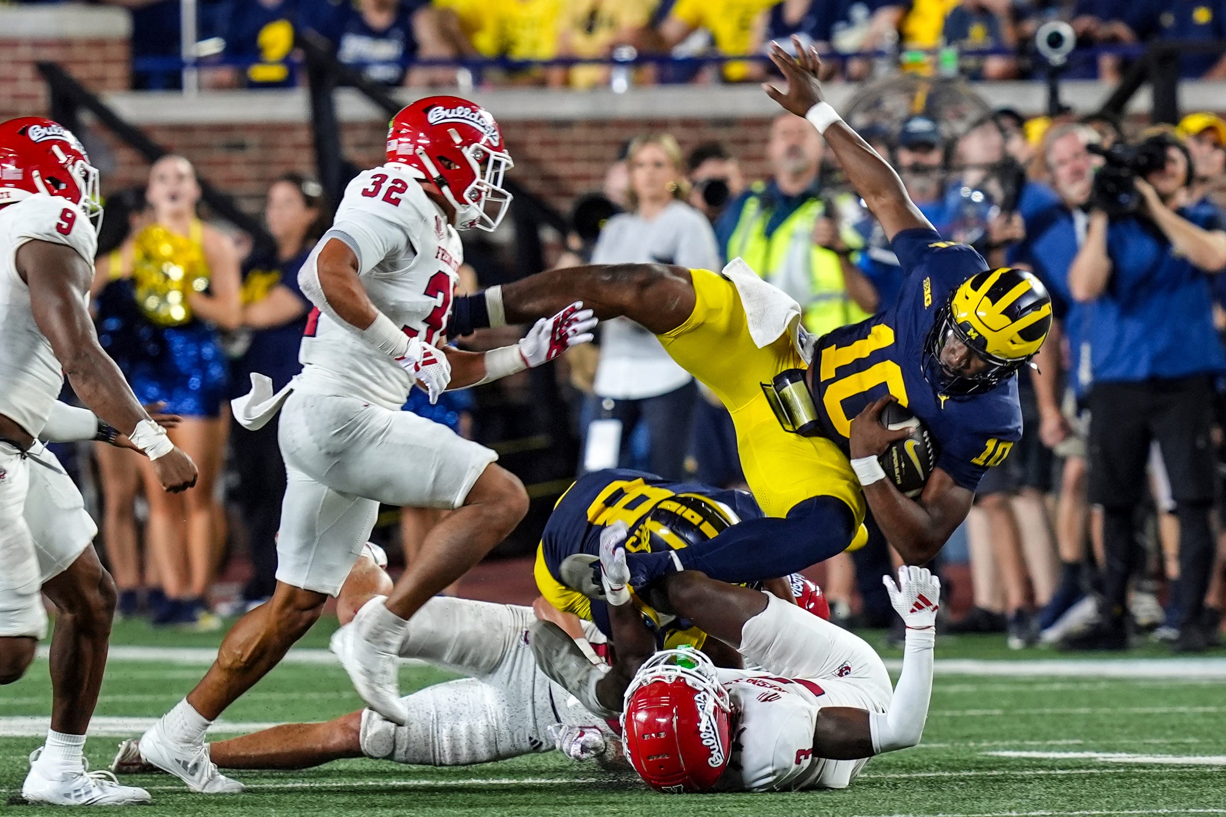 Michigan quarterback Alex Orji (10) is tackled by Fresno State defensive back Al'zillion Hamilton (3) during the second half at Michigan Stadium in Ann Arbor on Saturday, Aug. 31, 2024.
