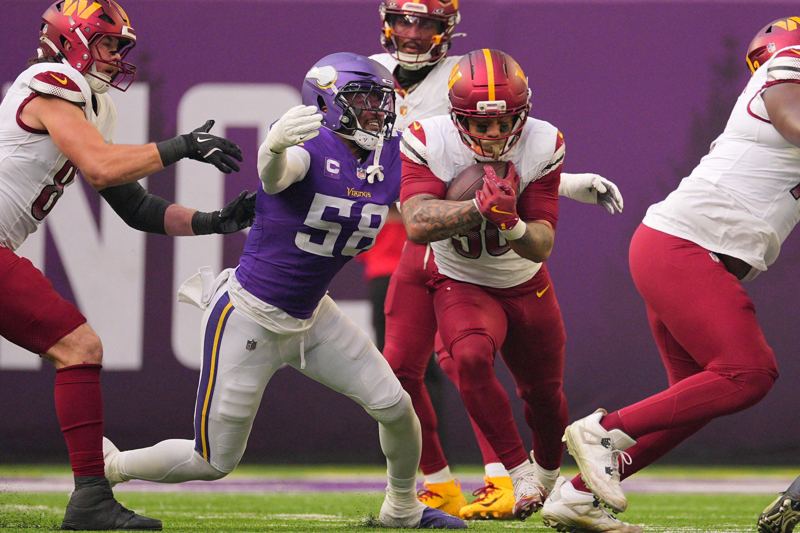 Dec 7, 2025; Minneapolis, Minnesota, USA; Washington Commanders running back Chris Rodriguez Jr. (36) rushes the ball against Minnesota Vikings linebacker Jonathan Greenard (58) during the first half at U.S. Bank Stadium.