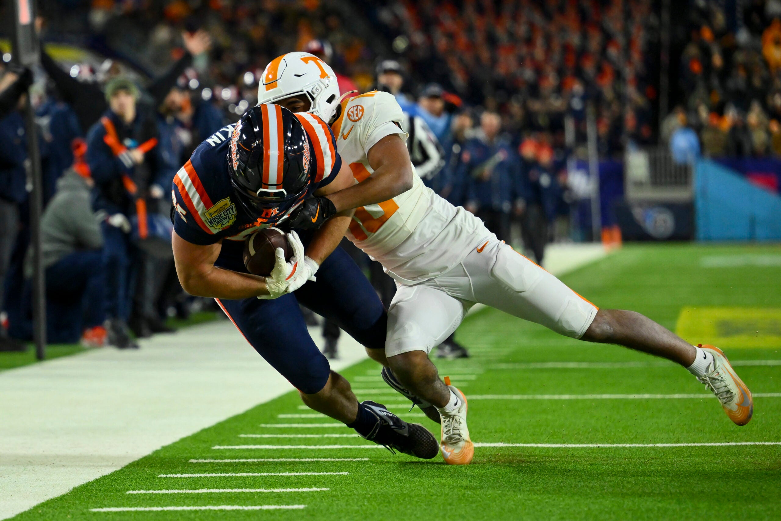 Dec 30, 2025; Nashville, TN, USA; Illinois Fighting Illini tight end Tanner Arkin (85) drags Tennessee Volunteers defensive back Kaleb Beasley (10) during the second half at Nissan Stadium.