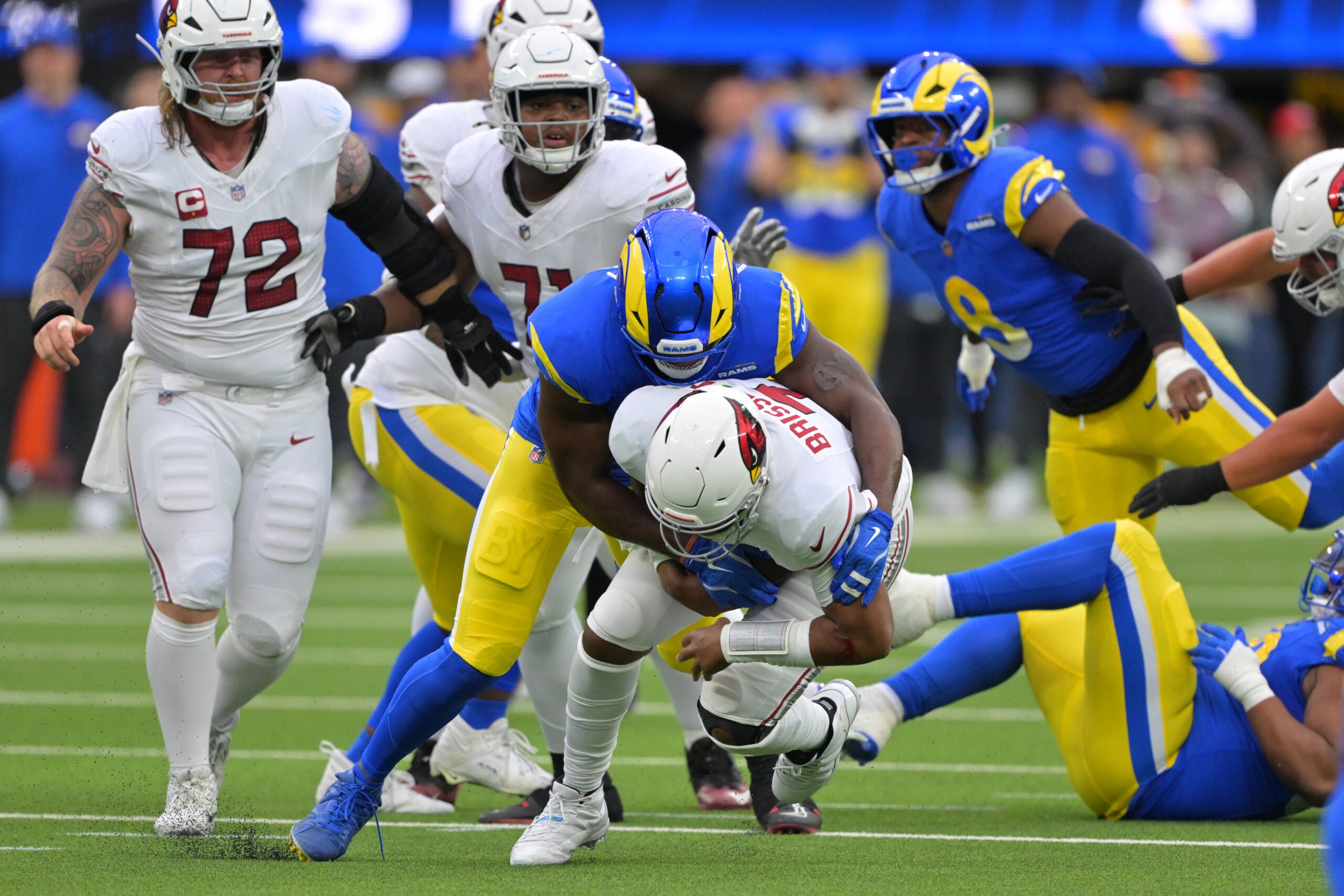 Jan 4, 2026; Inglewood, California, USA; Arizona Cardinals quarterback Jacoby Brissett (7) is sacked by Los Angeles Rams linebacker Byron Young (0) during the first half at SoFi Stadium.