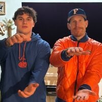 Florida Gators offensive line coach Phil Trautwein does the Gator chomp while visiting 2027 five-star offensive line recruit Maxwell Hiller.
