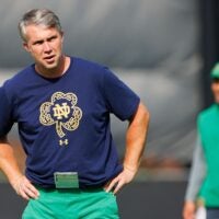Notre Dame quarterbacks coach Gino Guidugli watches players warm up during a Notre Dame football practice at Irish Athletic Center on Tuesday, Aug. 6, 2024, in South Bend.
