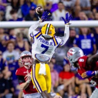Sep 7, 2024; Baton Rouge, Louisiana, USA; Nicholls State Colonels quarterback Pat McQuaide (7) rolls out of the pocket against LSU Tigers linebacker Harold Perkins Jr. (7) during the second half at Tiger Stadium.
