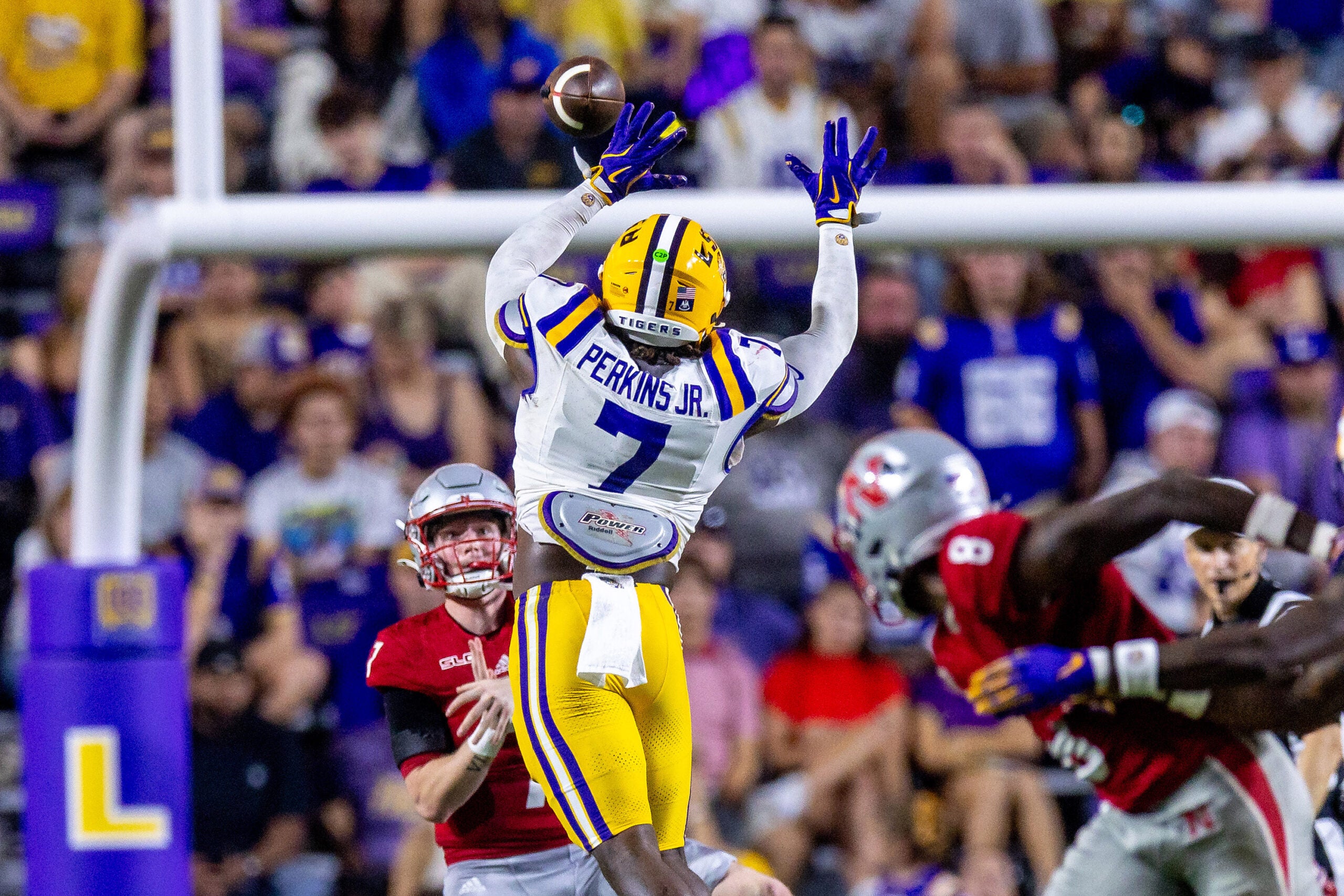 Sep 7, 2024; Baton Rouge, Louisiana, USA; Nicholls State Colonels quarterback Pat McQuaide (7) rolls out of the pocket against LSU Tigers linebacker Harold Perkins Jr. (7) during the second half at Tiger Stadium.