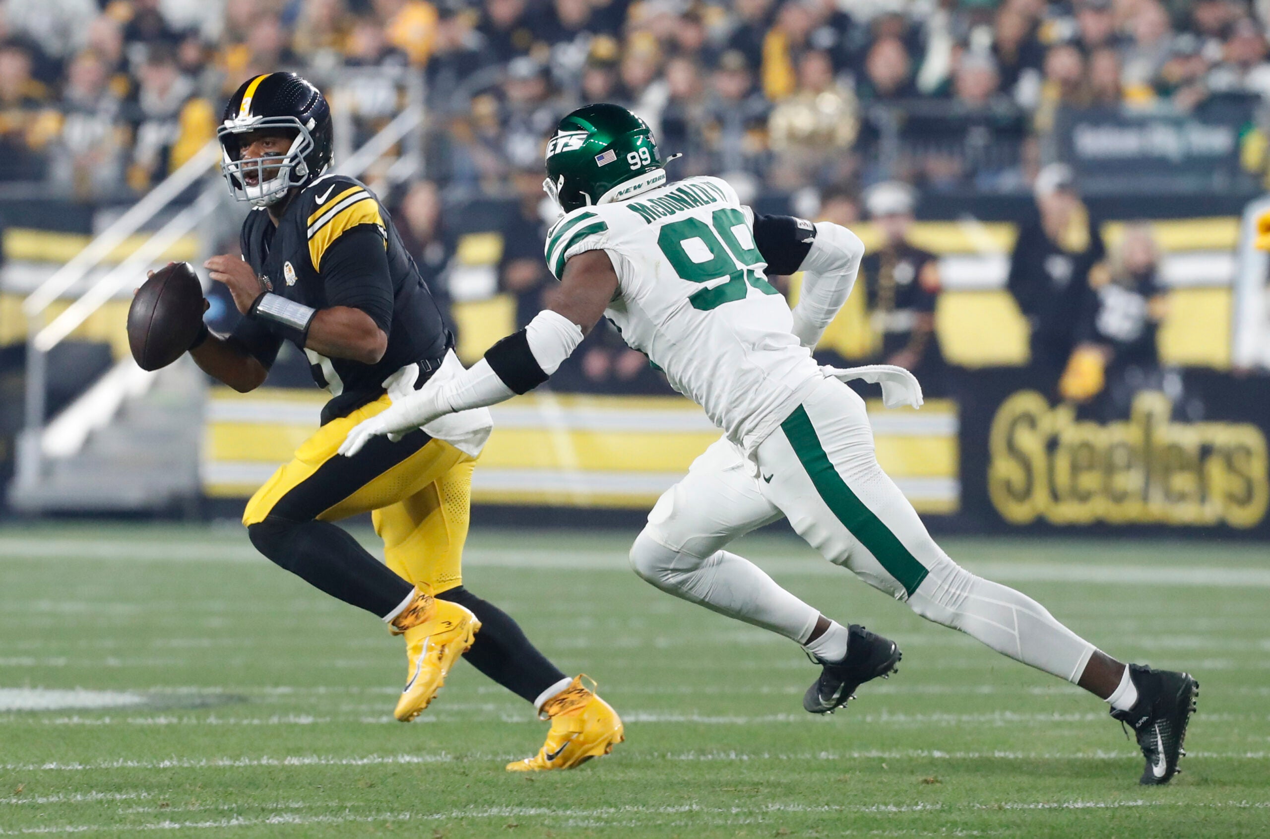 Oct 20, 2024; Pittsburgh, Pennsylvania, USA; Pittsburgh Steelers quarterback Russell Wilson (3) scrambles against pressure from New York Jets defensive end Will McDonald IV (99) during the first quarter at Acrisure Stadium.