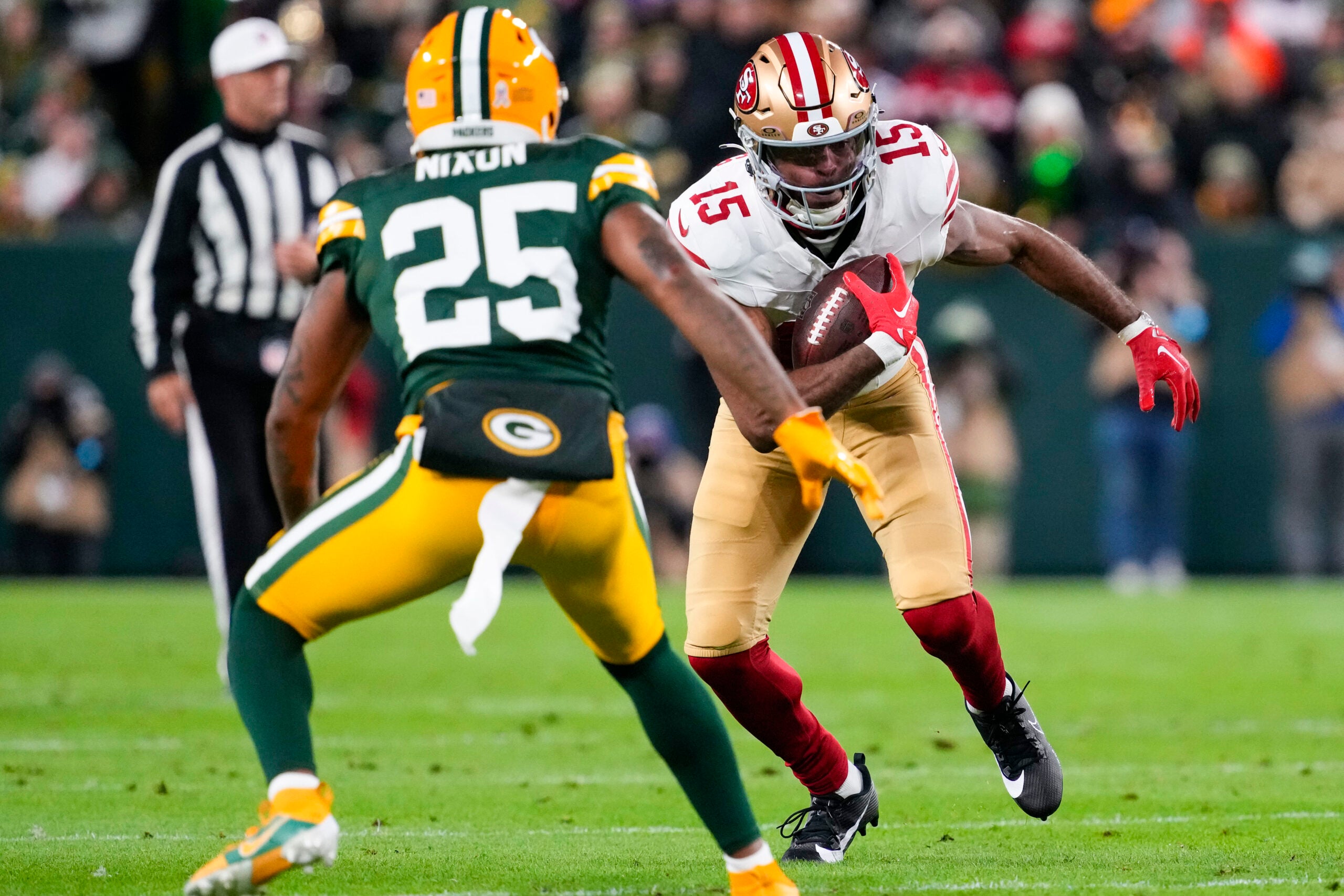 Nov 24, 2024; Green Bay, Wisconsin, USA; San Francisco 49ers wide receiver Jauan Jennings (15) rushes with the football as Green Bay Packers cornerback Keisean Nixon (25) defends during the second quarter at Lambeau Field.