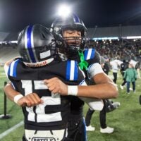 Montgomery Catholic's Kingston Preyear (1) and Montgomery Catholic's Micheal Sheffield (12) hug after the Class 5A football state championship at Protective Stadium in Birmingham, Ala., on Thursday, Dec. 5, 2024. Montgomery Catholic defeated Moody 17-14.