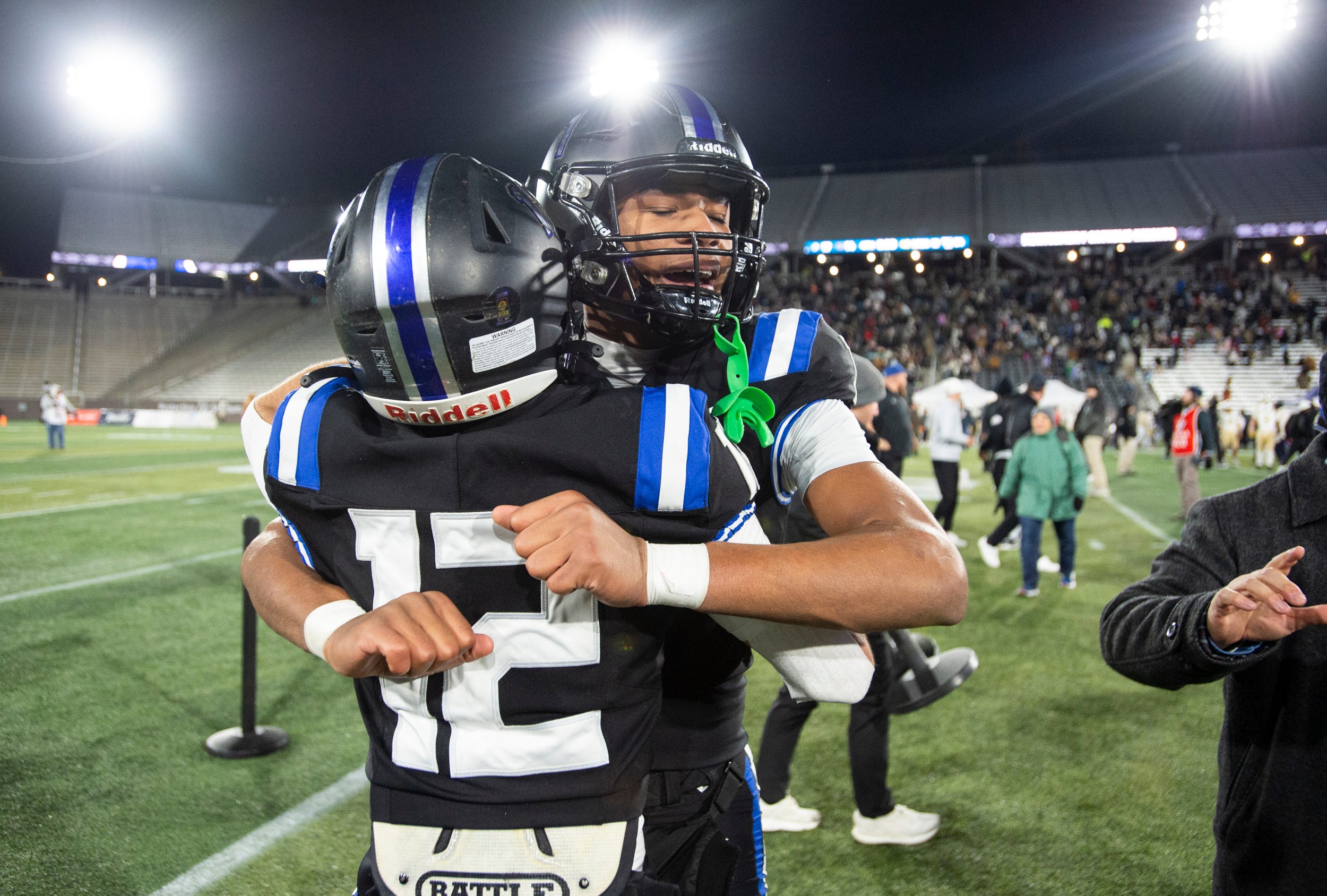 Montgomery Catholic's Kingston Preyear (1) and Montgomery Catholic's Micheal Sheffield (12) hug after the Class 5A football state championship at Protective Stadium in Birmingham, Ala., on Thursday, Dec. 5, 2024. Montgomery Catholic defeated Moody 17-14.
