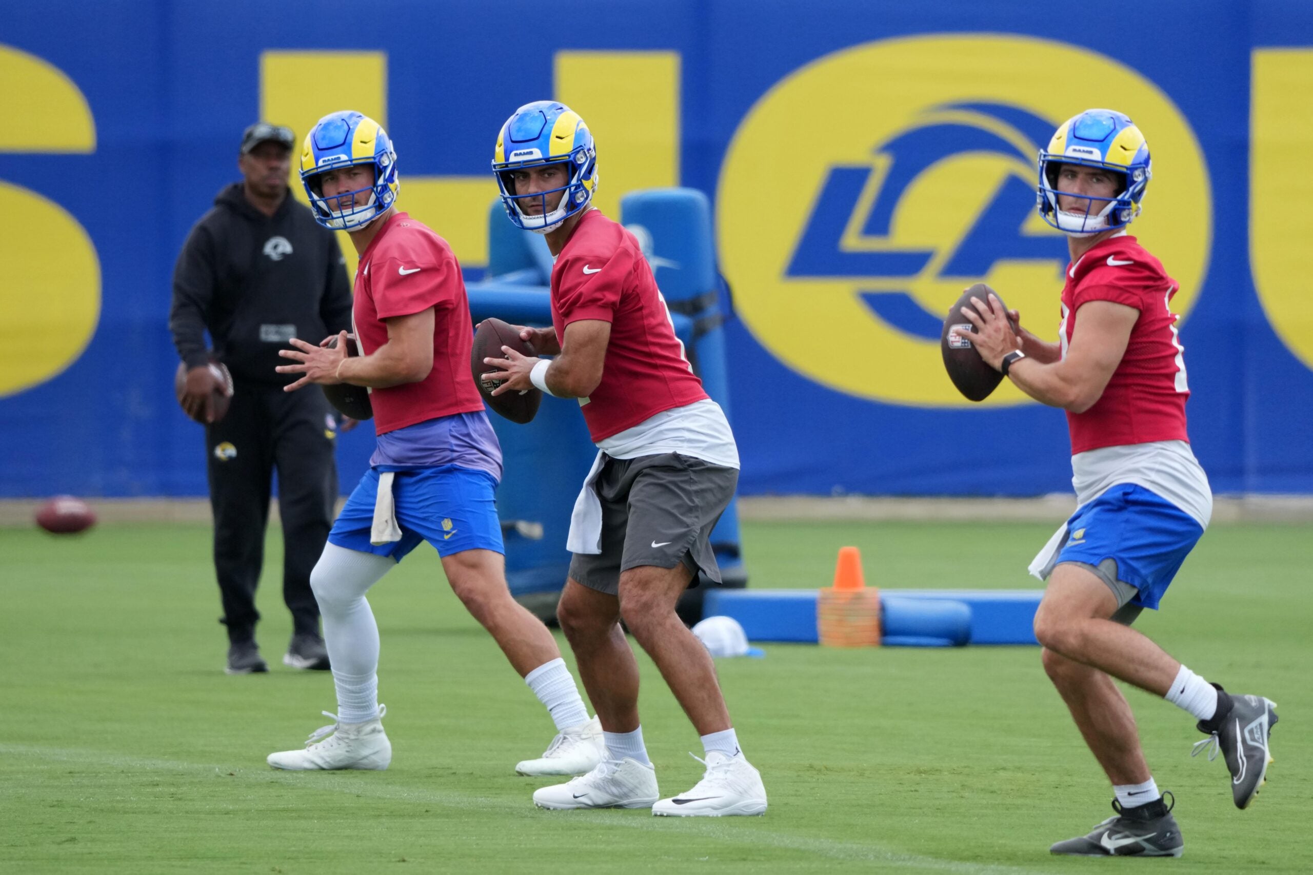 Jun 3, 2025; Woodland Hills, CA, USA; Los Angeles Rams quarterbacks Matthew Stafford (left), Jimmy Garoppolo (center) and Stetson Bennett throw the ball during organized team activities at Rams Practice Facility.