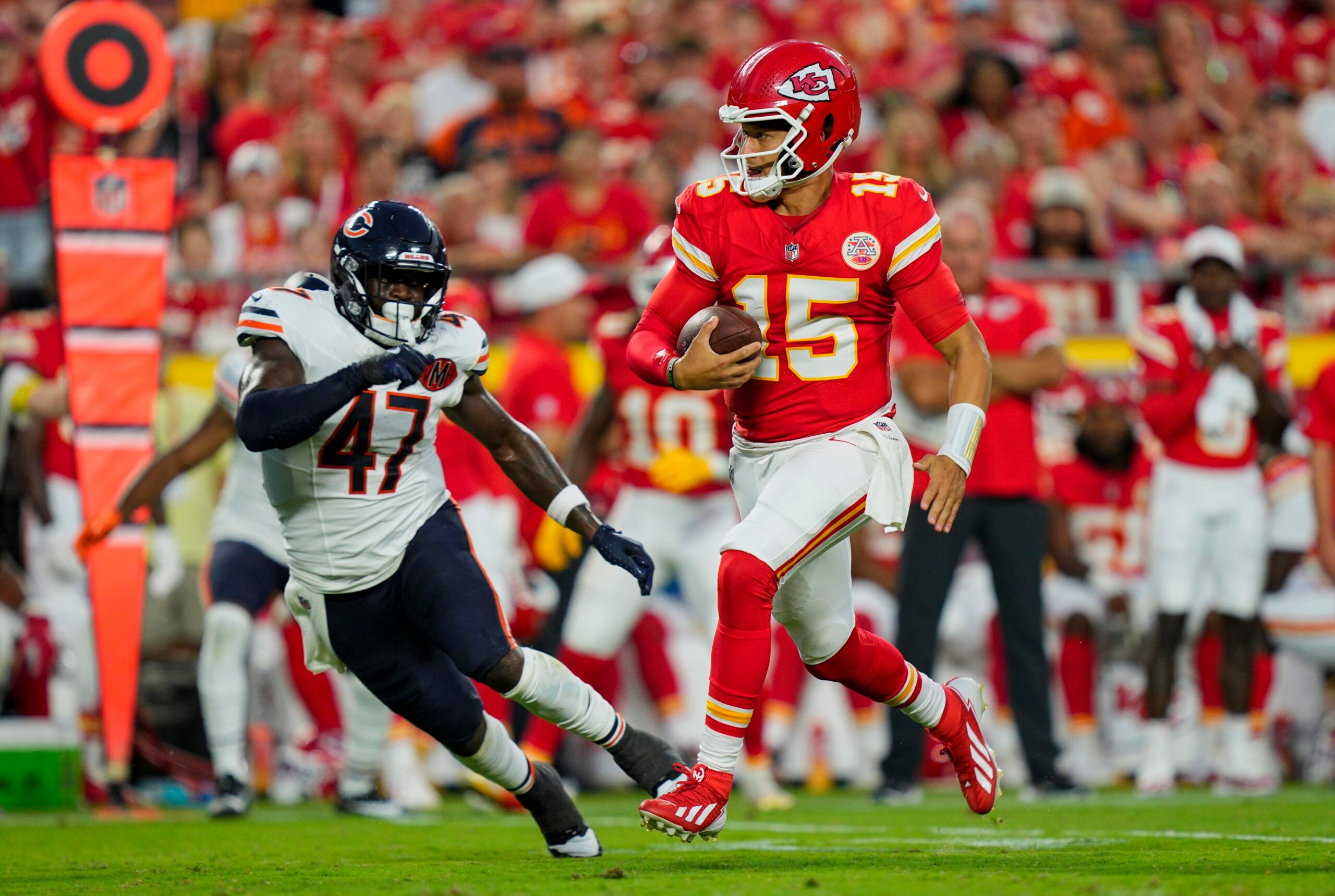 Aug 22, 2025; Kansas City, Missouri, USA; Kansas City Chiefs quarterback Patrick Mahomes (15) runs the ball against Chicago Bears linebacker Ruben Hyppolite II (47) during the first half at GEHA Field at Arrowhead Stadium.