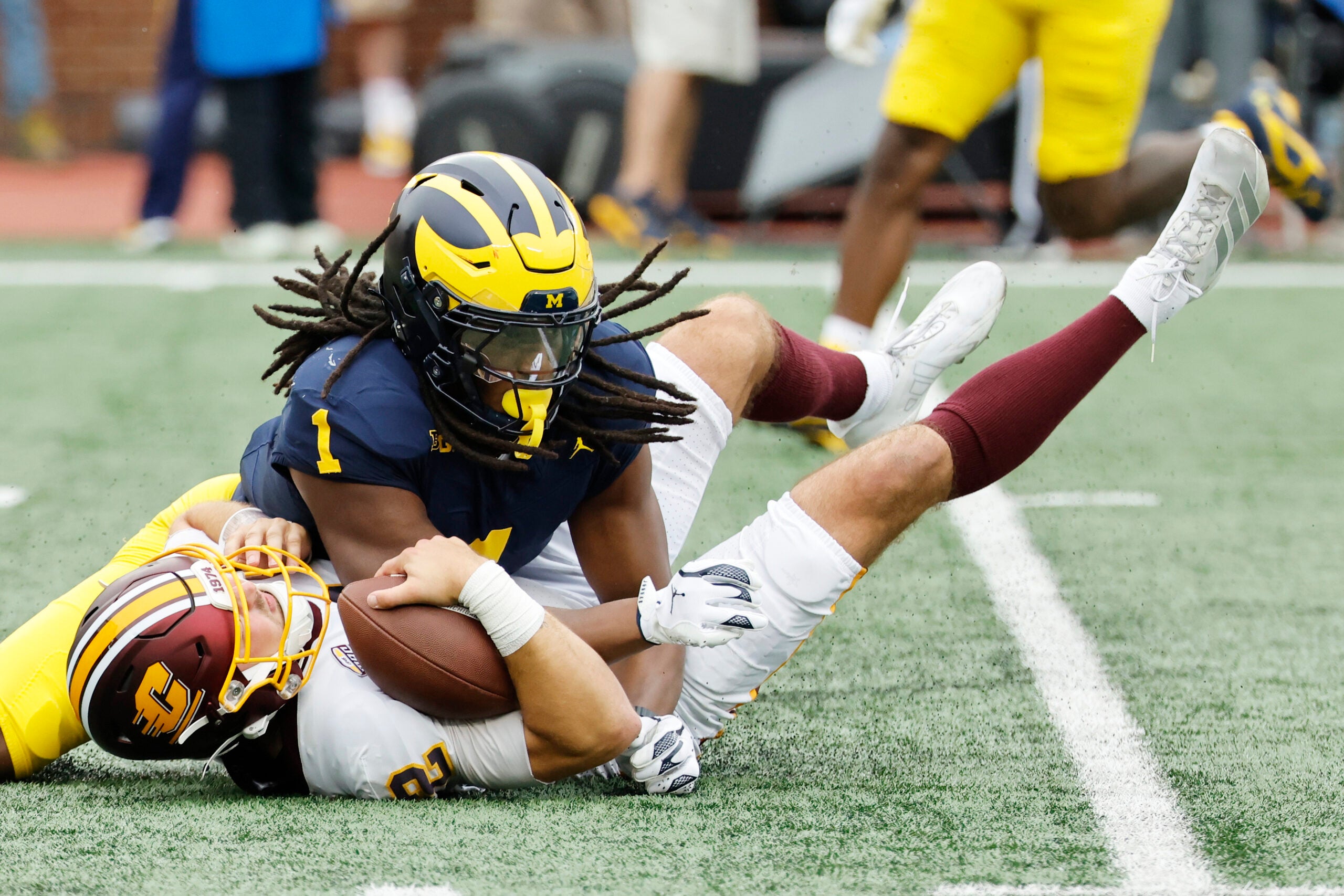 Sep 13, 2025; Ann Arbor, Michigan, USA; Central Michigan Chippewas quarterback Joe Labas (2) is sacked by Michigan Wolverines linebacker Jaishawn Barham (1) in the first half at Michigan Stadium.