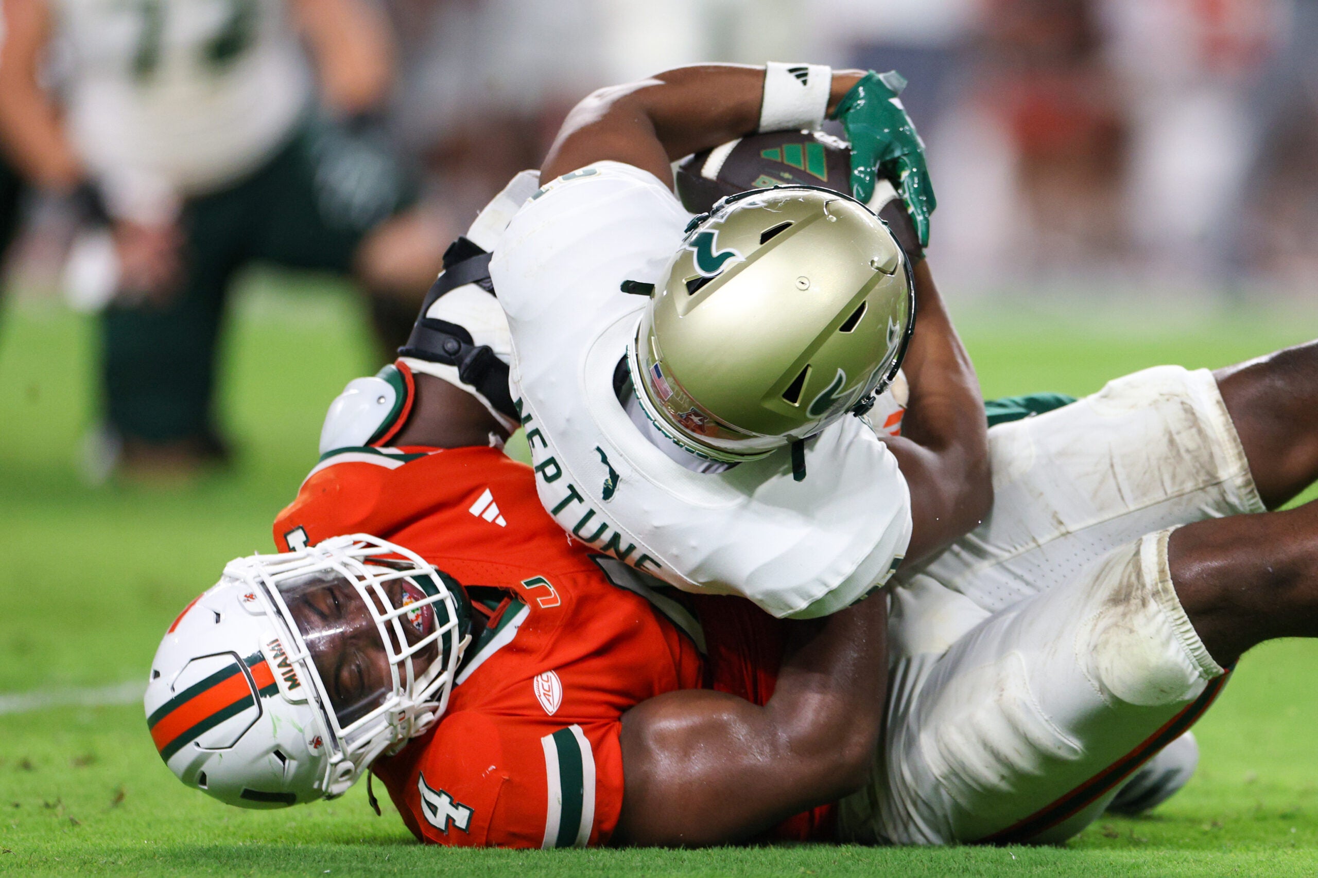 Sep 13, 2025; Miami Gardens, Florida, USA; Miami Hurricanes defensive lineman Rueben Bain Jr. (4) tackles South Florida Bulls wide receiver Christian Neptune (81) in the third quarter at Hard Rock Stadium.
