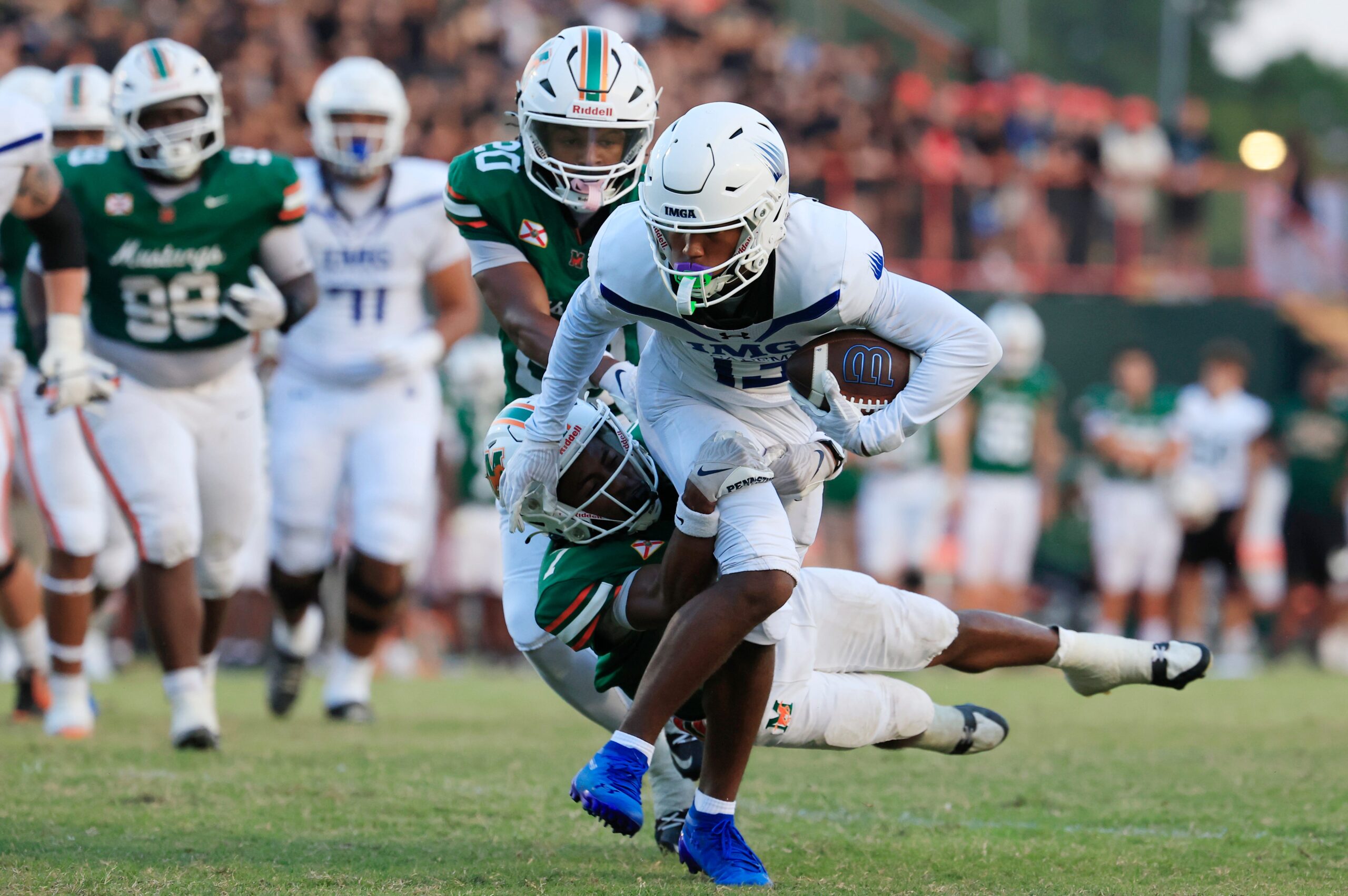 IMG Academy's Osani Gayles (13) rushes for yards against Mandarin's Tamajh Mitchell (7) during the first quarter of a high school football matchup at Mandarin High School, Friday, Sept. 19, 2025, in Jacksonville, Fla. The IMG Academy Ascenders defeated the Mandarin Mustangs 57-7.