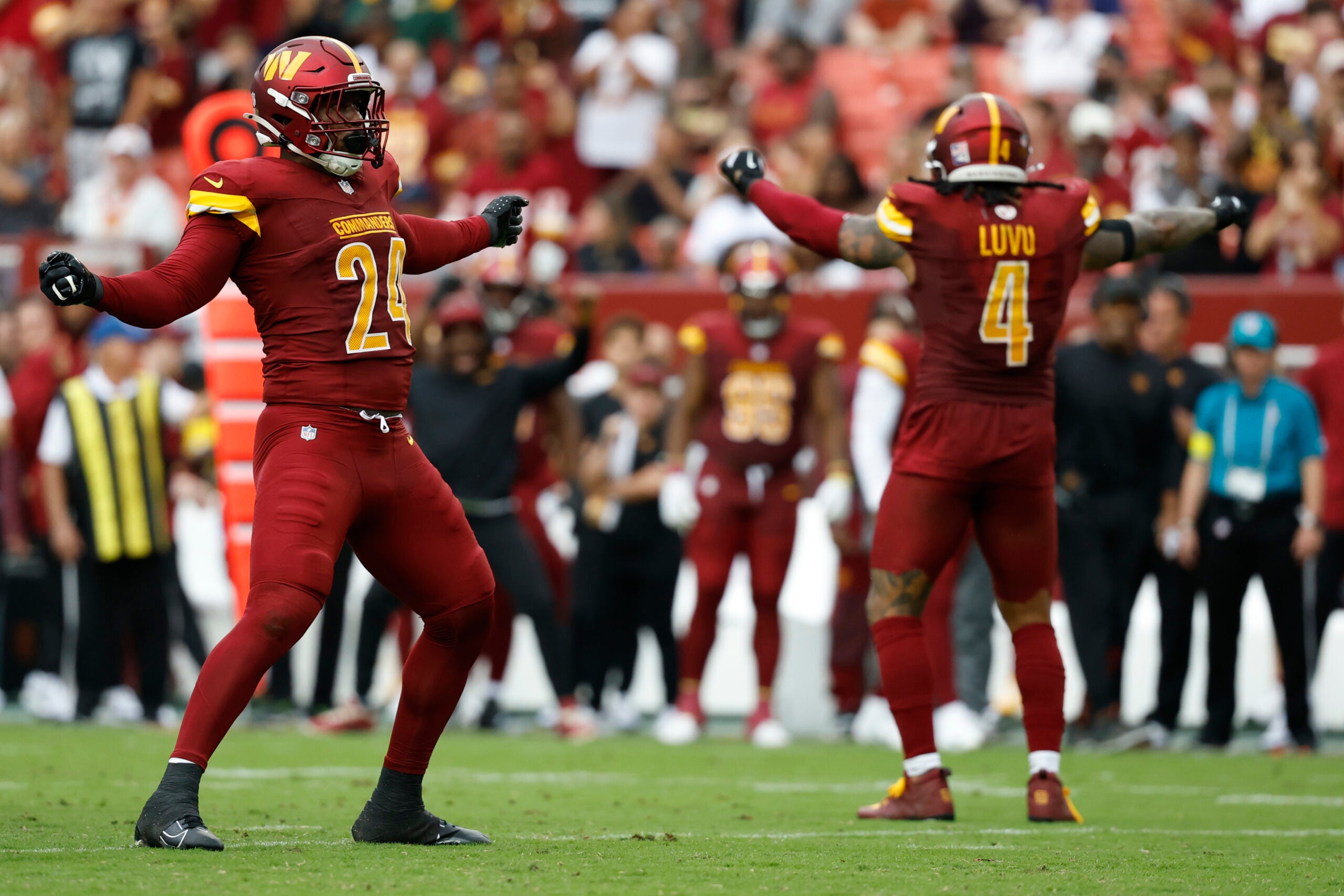 Sep 21, 2025; Landover, Maryland, USA; Washington Commanders outside linebacker Von Miller (24) celebrates with Commanders linebacker Frankie Luvu (4) after recording a sack against the Las Vegas Raiders during the third quarter at Northwest Stadium.