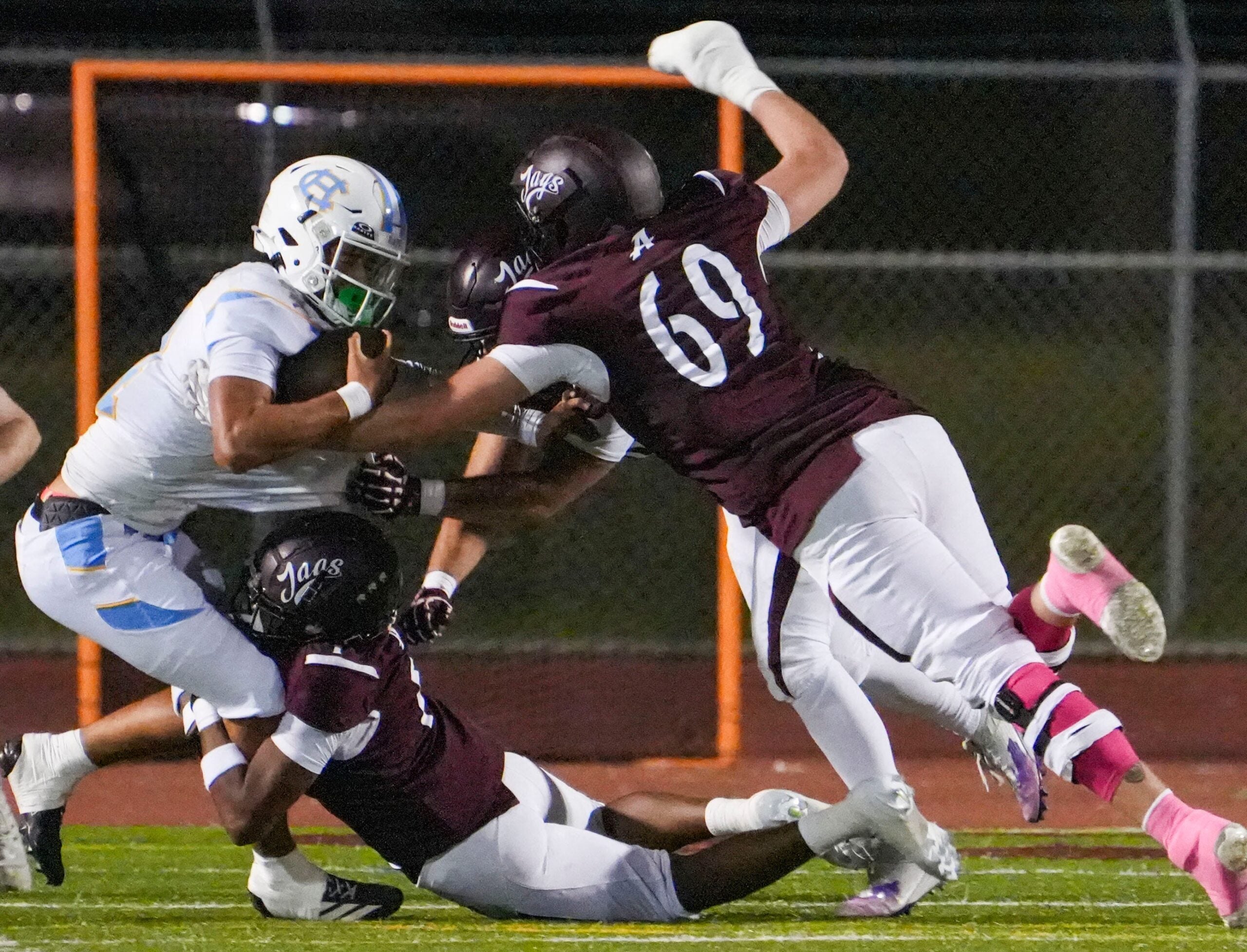 Cape Henlopen's Jameson Tingle is sacked on consecutive plays in the first quarter by Appoquinimink defenders including Harold Seamon (bottom) and Layton von Brandt in the Jaguars' 48-14 win at Appoquinimink High School, Oct 3, 2025.