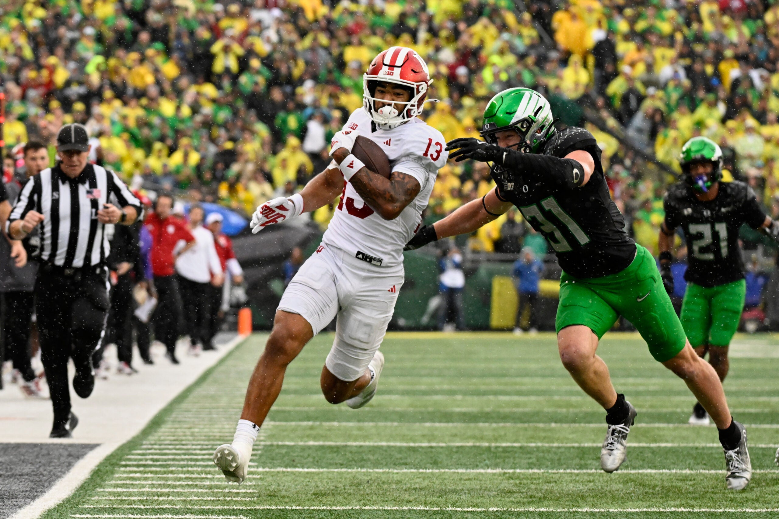 Oct 11, 2025; Eugene, Oregon, USA; Indiana Hoosiers wide receiver Elijah Sarratt (13) runs with the ball after making a catch against Oregon Ducks defensive back Dillon Thieneman (31) during the fourth quarter at Autzen Stadium.