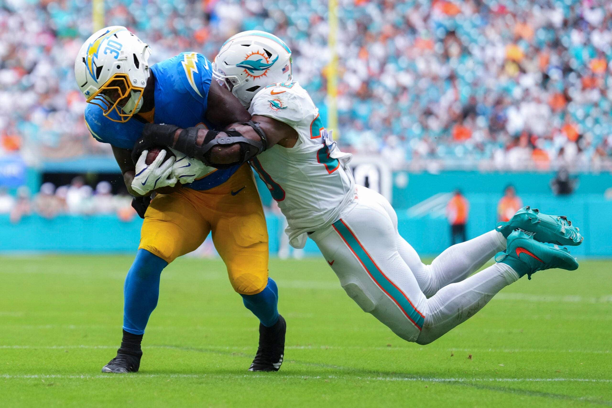 Oct 12, 2025; Miami Gardens, Florida, USA; Miami Dolphins linebacker Jordyn Brooks (20) tackles Los Angeles Chargers running back Kimani Vidal (30) during the third quarter at Hard Rock Stadium.
