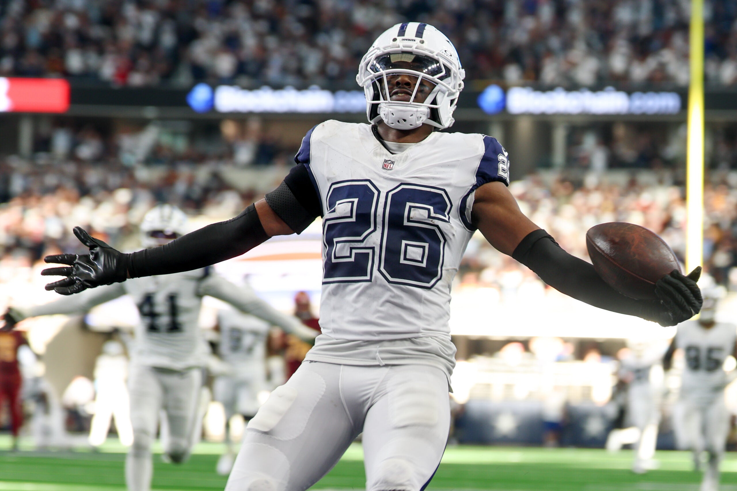 Oct 19, 2025; Arlington, Texas, USA; Dallas Cowboys cornerback Daron Bland (26) carries the ball after an interception for a touchdown against the Washington Commanders during the third quarter of the game at AT&T Stadium.