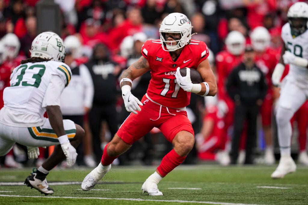 Oct 25, 2025; Cincinnati, Ohio, USA;  Cincinnati Bearcats tight end Joe Royer (11) carries the ball after making a catch against Baylor Bears safety DJ Coleman (33) in the first half at Nippert Stadium. Mandatory Credit: Aaron Doster-Imagn Images