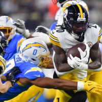 Nov 9, 2025; Inglewood, California, USA; Pittsburgh Steelers running back Kaleb Johnson (20) carries the ball defended by Los Angeles Chargers linebacker Daiyan Henley (0) during the second quarter of the game at SoFi Stadium.