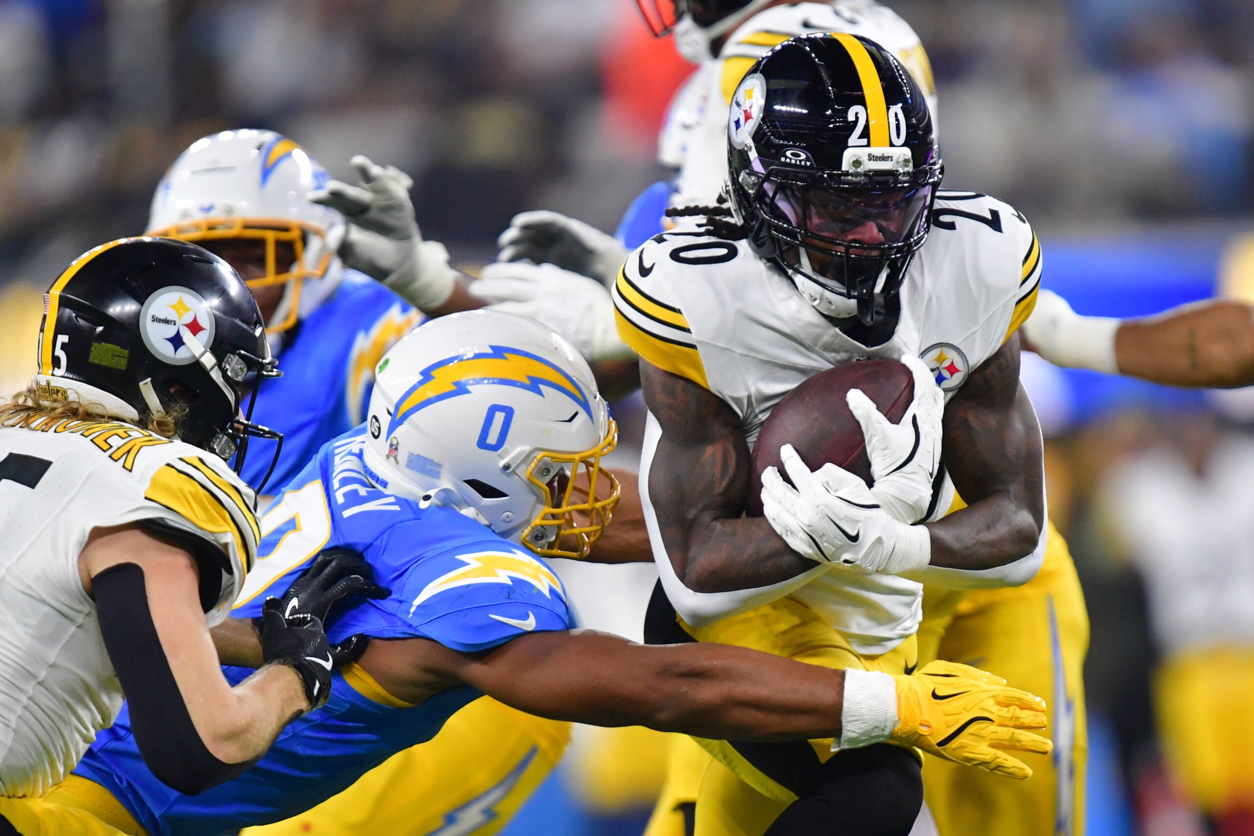 Nov 9, 2025; Inglewood, California, USA; Pittsburgh Steelers running back Kaleb Johnson (20) carries the ball defended by Los Angeles Chargers linebacker Daiyan Henley (0) during the second quarter of the game at SoFi Stadium.