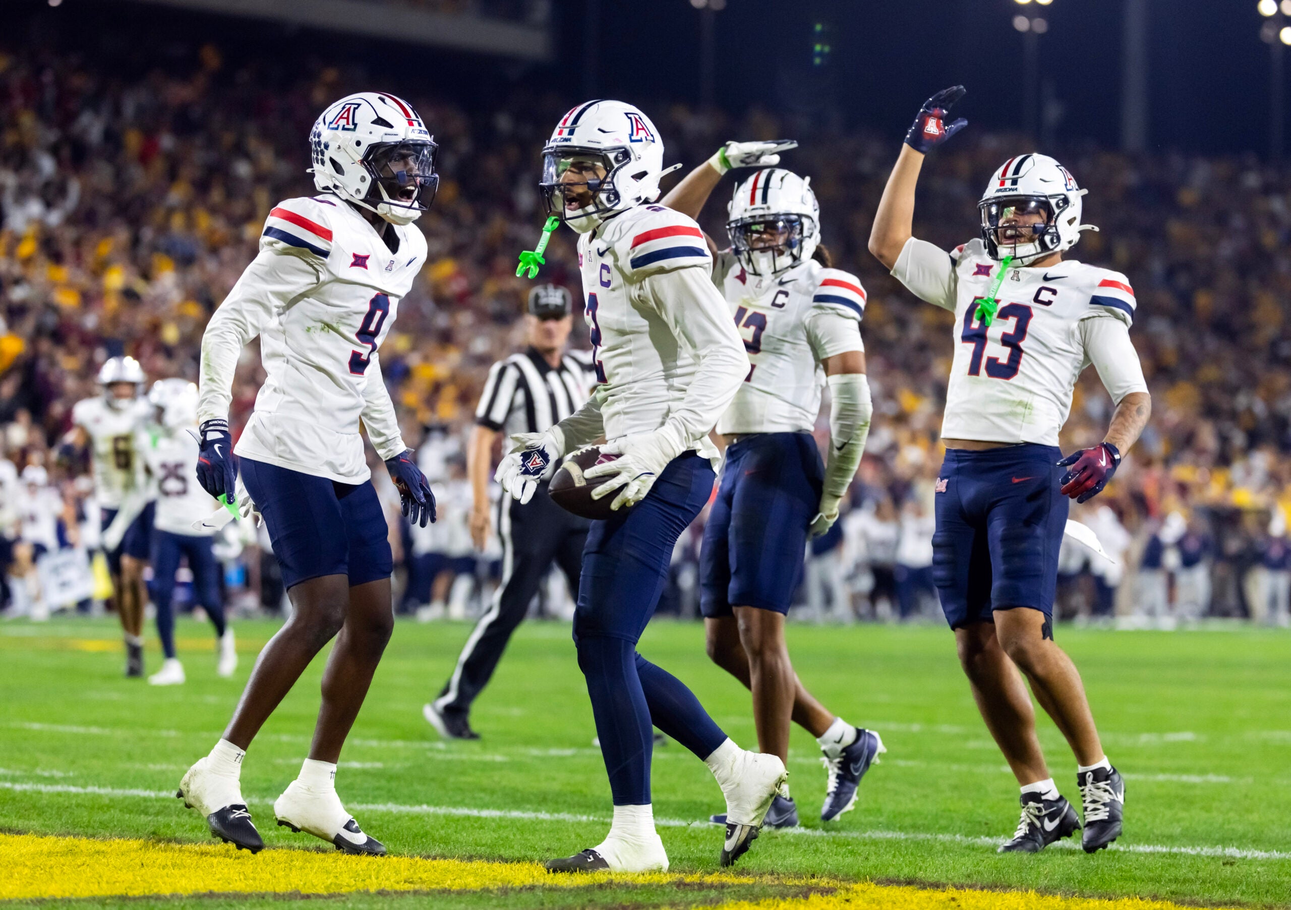Nov 28, 2025; Tempe, Arizona, USA; Arizona Wildcats defensive back Treydan Stukes (2) celebrates with defensive back Ayden Garnes (9) after an interception against Arizona State Sun Devils in the second half during the 99th Territorial Cup at Mountain America Stadium.