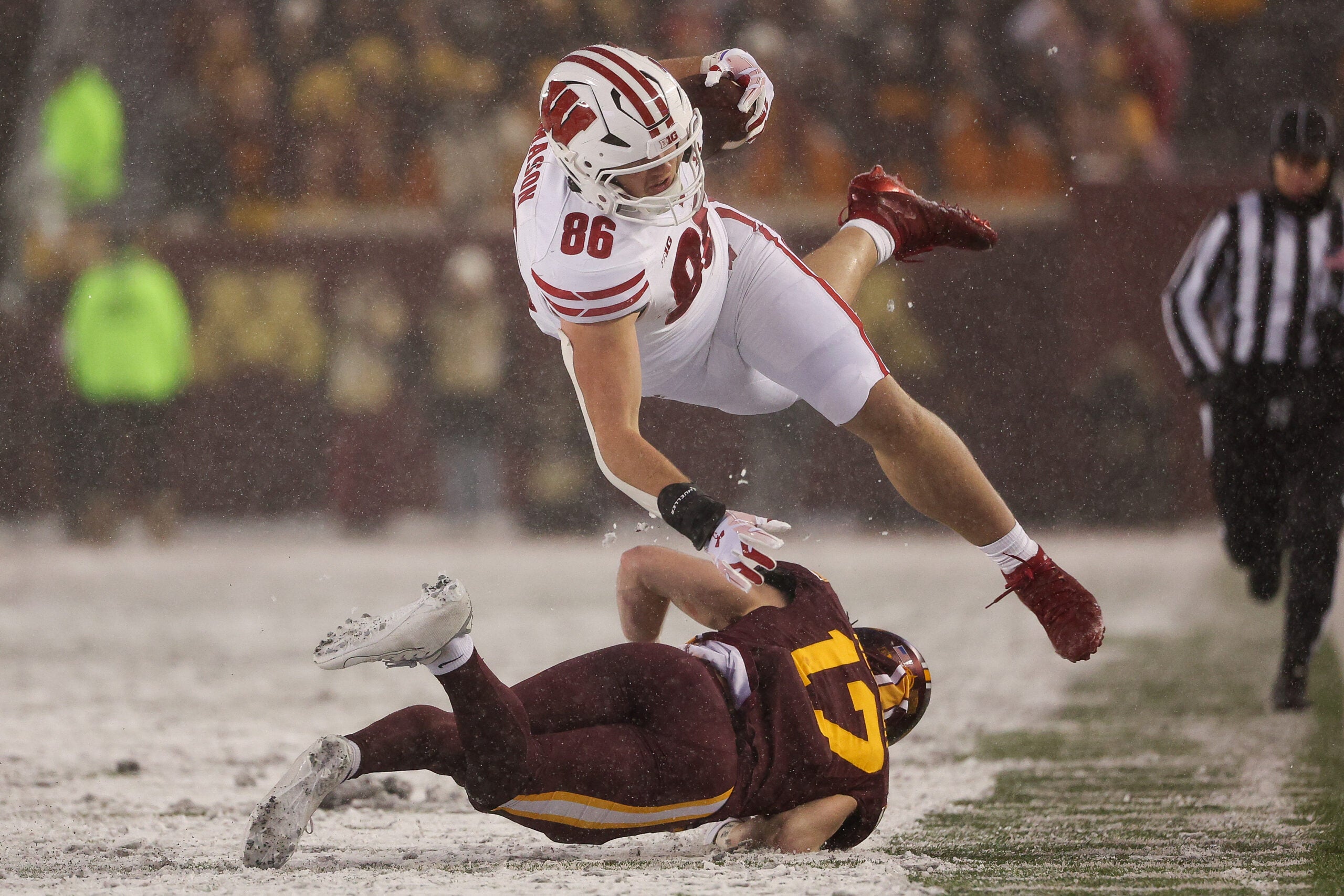 Nov 29, 2025; Minneapolis, Minnesota, USA; Minnesota Golden Gophers defensive back John Nestor (17) tackles Wisconsin Badgers tight end Lance Mason (86) during the second half at Huntington Bank Stadium.