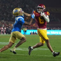 Nov 29, 2025; Los Angeles, California, USA; Southern California Trojans wide receiver Makai Lemon (6) carries the ball against UCLA Bruins defensive back Andre Jordan Jr. (2) in the second half at United Airlines Field at Los Angeles Memorial Coliseum.