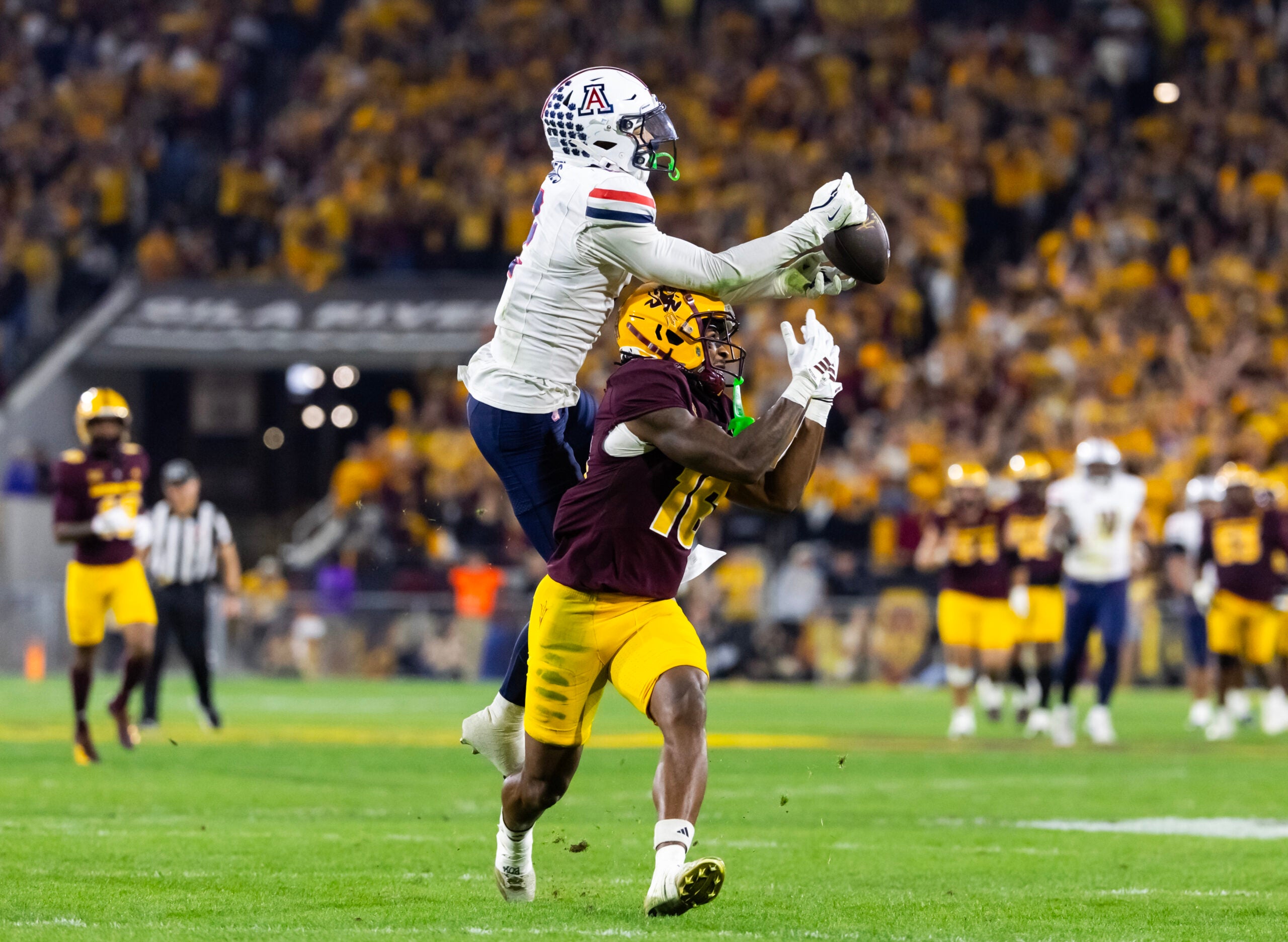 Nov 28, 2025; Tempe, Arizona, USA; Arizona Wildcats defensive back Treydan Stukes (2) intercepts the ball against Arizona State Sun Devils wide receiver Jaren Hamilton (16) in the second half during the 99th Territorial Cup at Mountain America Stadium.