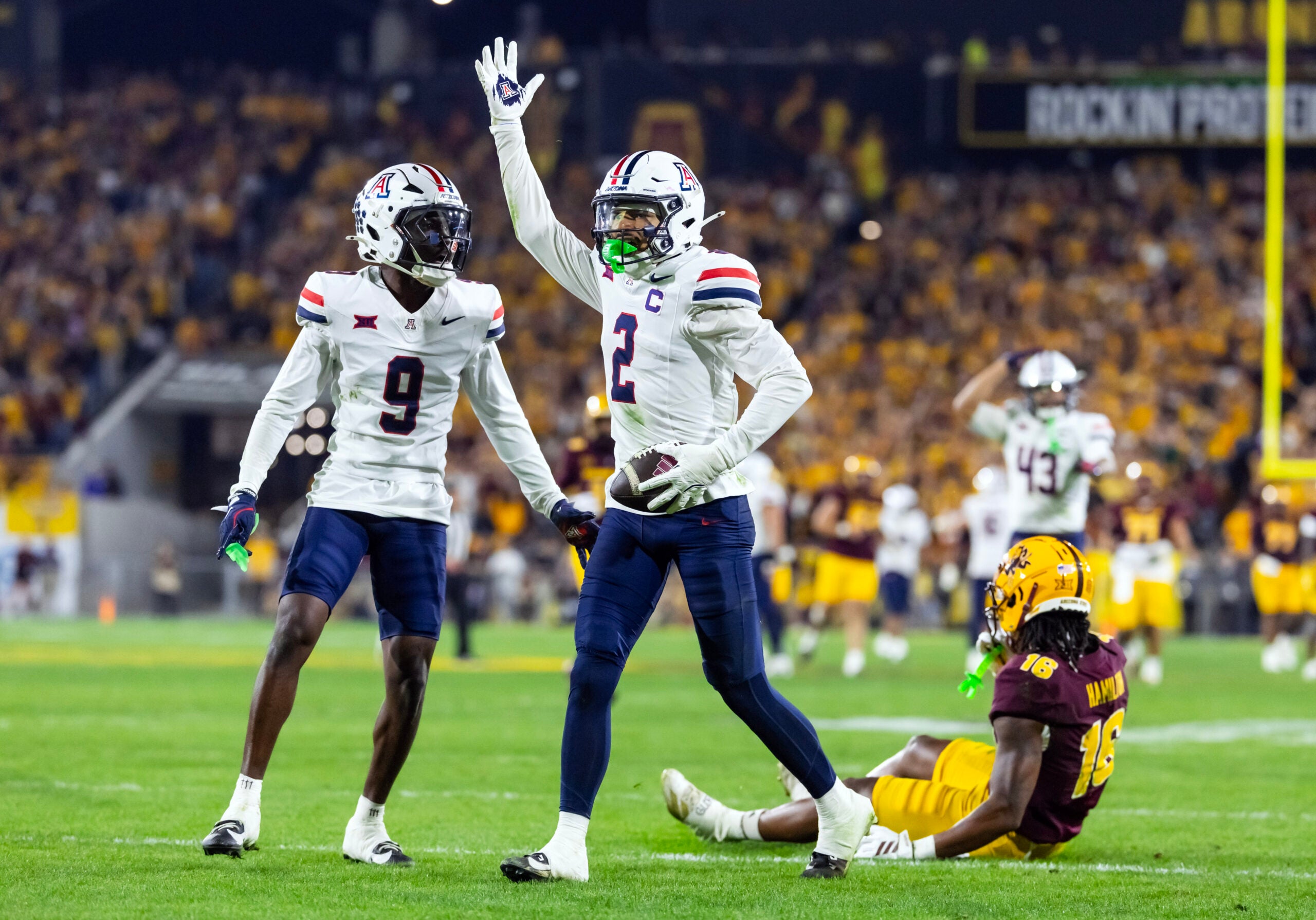 Nov 28, 2025; Tempe, Arizona, USA; Arizona Wildcats defensive back Treydan Stukes (2) celebrates with defensive back Ayden Garnes (9) after an interception against Arizona State Sun Devils in the second half during the 99th Territorial Cup at Mountain America Stadium.