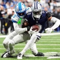 Detroit Lions cornerback Amik Robertson (21) tackles Dallas Cowboys wide receiver George Pickens (3) during the first half at Ford Field in Detroit on Thursday, Dec. 4, 2025.