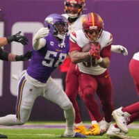 Dec 7, 2025; Minneapolis, Minnesota, USA; Washington Commanders running back Chris Rodriguez Jr. (36) rushes the ball against Minnesota Vikings linebacker Jonathan Greenard (58) during the first half at U.S. Bank Stadium.