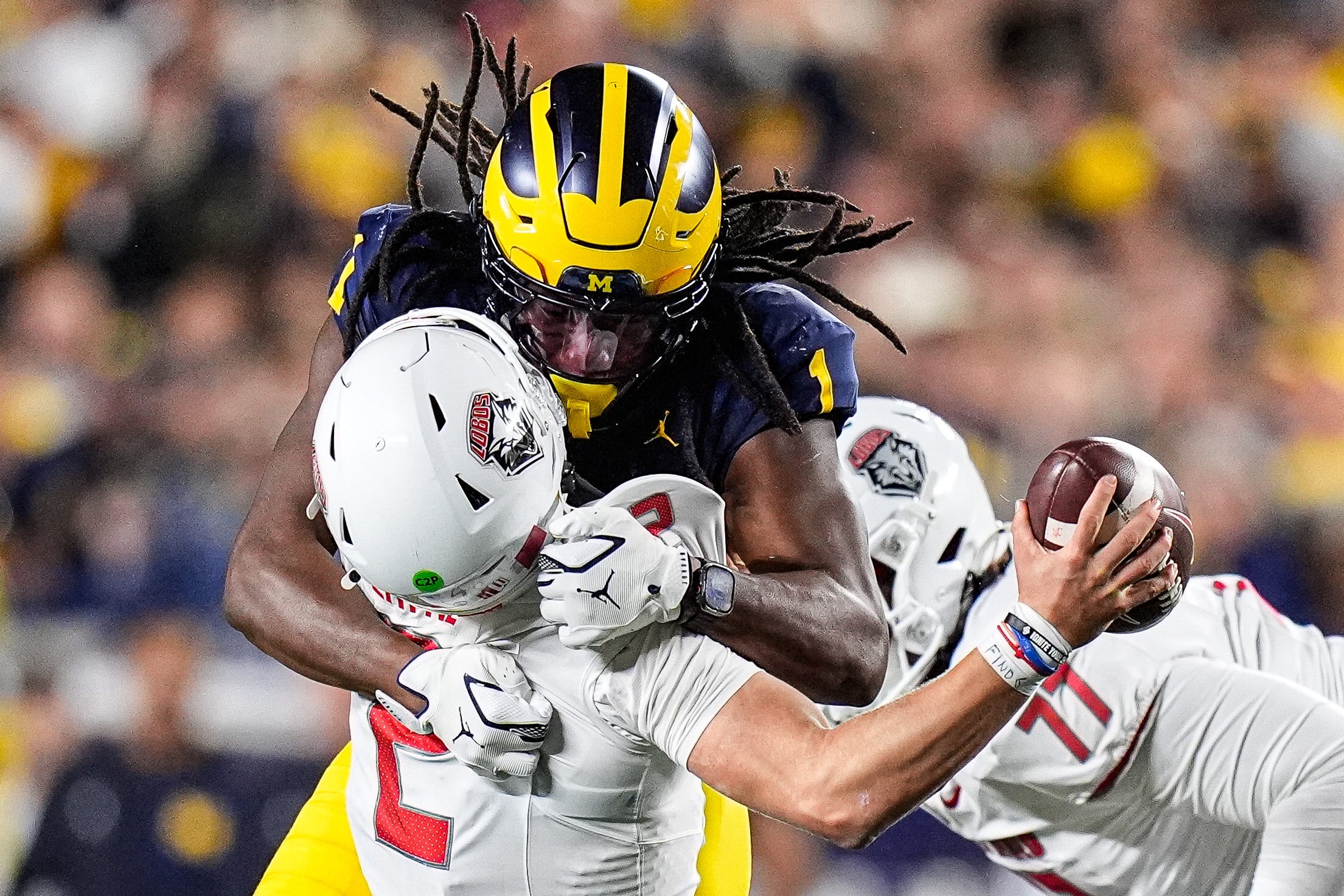 Michigan linebacker Jaishawn Barham (1) tackles New Mexico quarterback Jack Layne (2) during the second half at Michigan Stadium in Ann Arbor on Saturday, August 30, 2025.