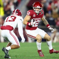 Dec 19, 2025; Norman, OK, USA; Oklahoma Sooners tight end Jaren Kanak (12) attempts to elude a tackle by Alabama Crimson Tide defensive back Ivan Taylor (13) in the first half at Gaylord Family OK Memorial Stadium.