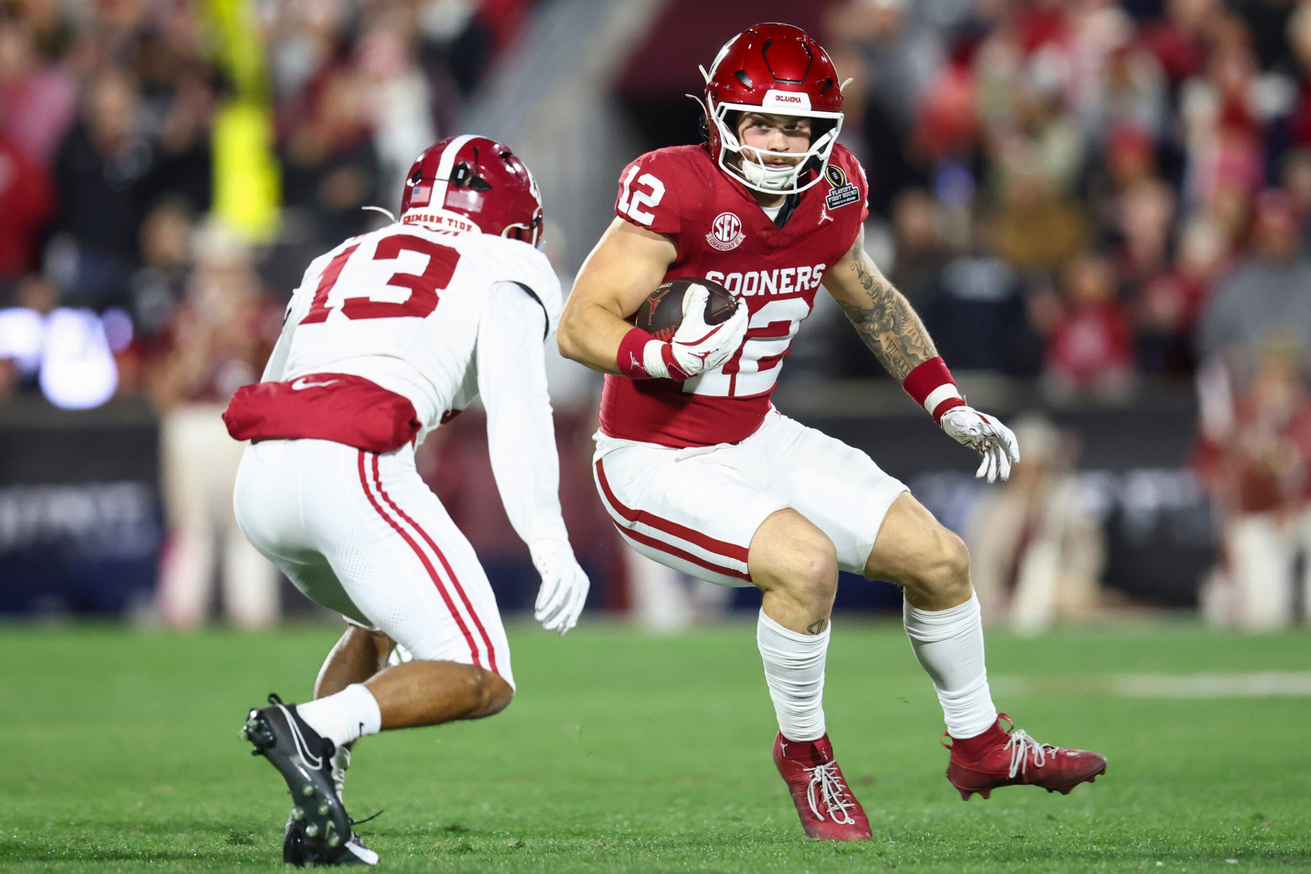 Dec 19, 2025; Norman, OK, USA; Oklahoma Sooners tight end Jaren Kanak (12) attempts to elude a tackle by Alabama Crimson Tide defensive back Ivan Taylor (13) in the first half at Gaylord Family OK Memorial Stadium.