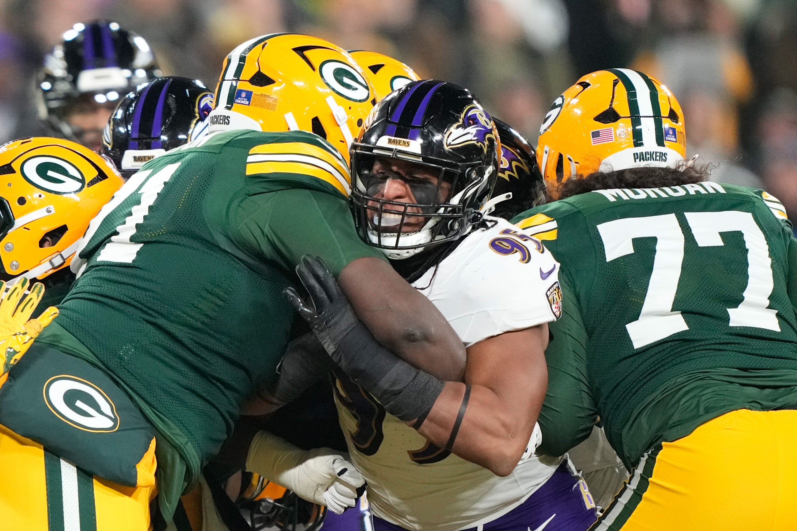 Dec 27, 2025; Green Bay, Wisconsin, USA; Baltimore Ravens linebacker Tavius Robinson (95) against Green Bay Packers offensive tackle Anthony Belton (71) and Green Bay Packers guard Jordan Morgan (77) during the second quarter at Lambeau Field.