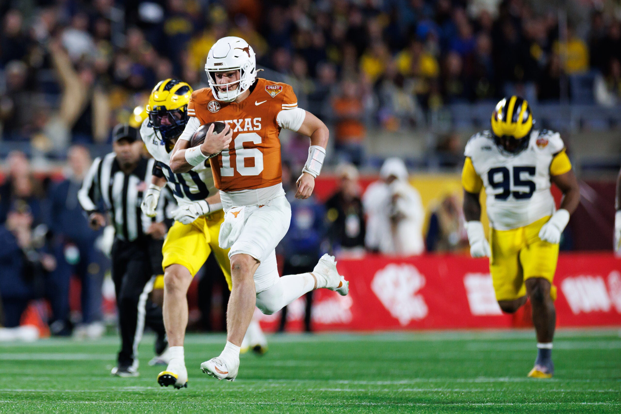 Dec 31, 2025; Orlando, FL, USA; Texas Longhorns quarterback Arch Manning (16) rushes with the ball for a touchdown against the Michigan Wolverines during the second half at Camping World Stadium.
