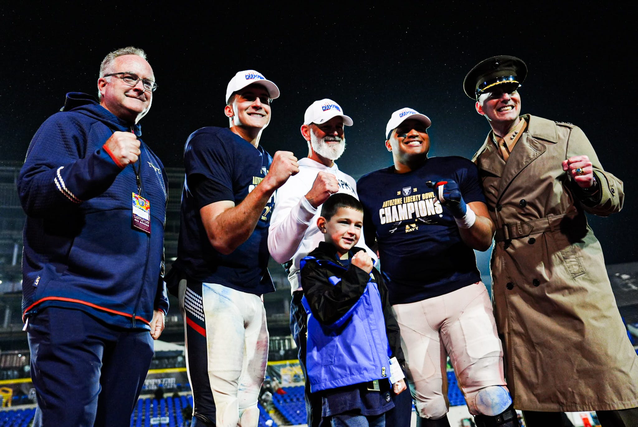Navy’s Blake Horvath (11), middle left, head coach Brian Newberry, Landon Robinson, and Navy Superintendent Lieutenant General Michael Borgschulte pose for a photo as they become the new AutoZone Liberty Bowl champions after defeating the Cincinnati Bearcats on Jan. 2, 2026 at Simmons Bank Liberty Stadium in Memphis, Tenn.