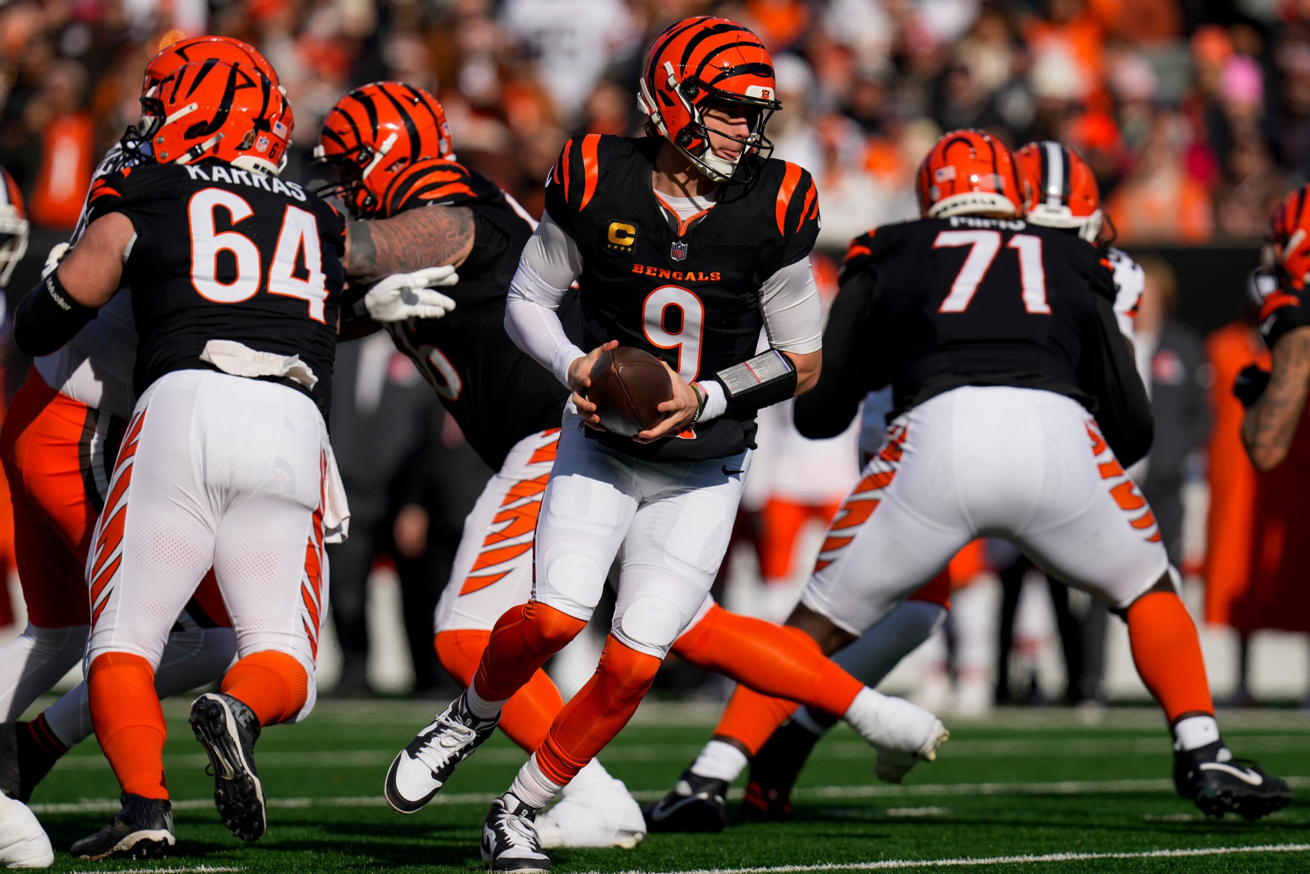 Cincinnati Bengals quarterback Joe Burrow (9) rolls out to hand off in the first quarter of the NFL Week 18 game between the Cincinnati Bengals and the Cleveland Browns at Paycor Stadium in Downtown Cincinnati on Sunday, Jan. 4, 2026.