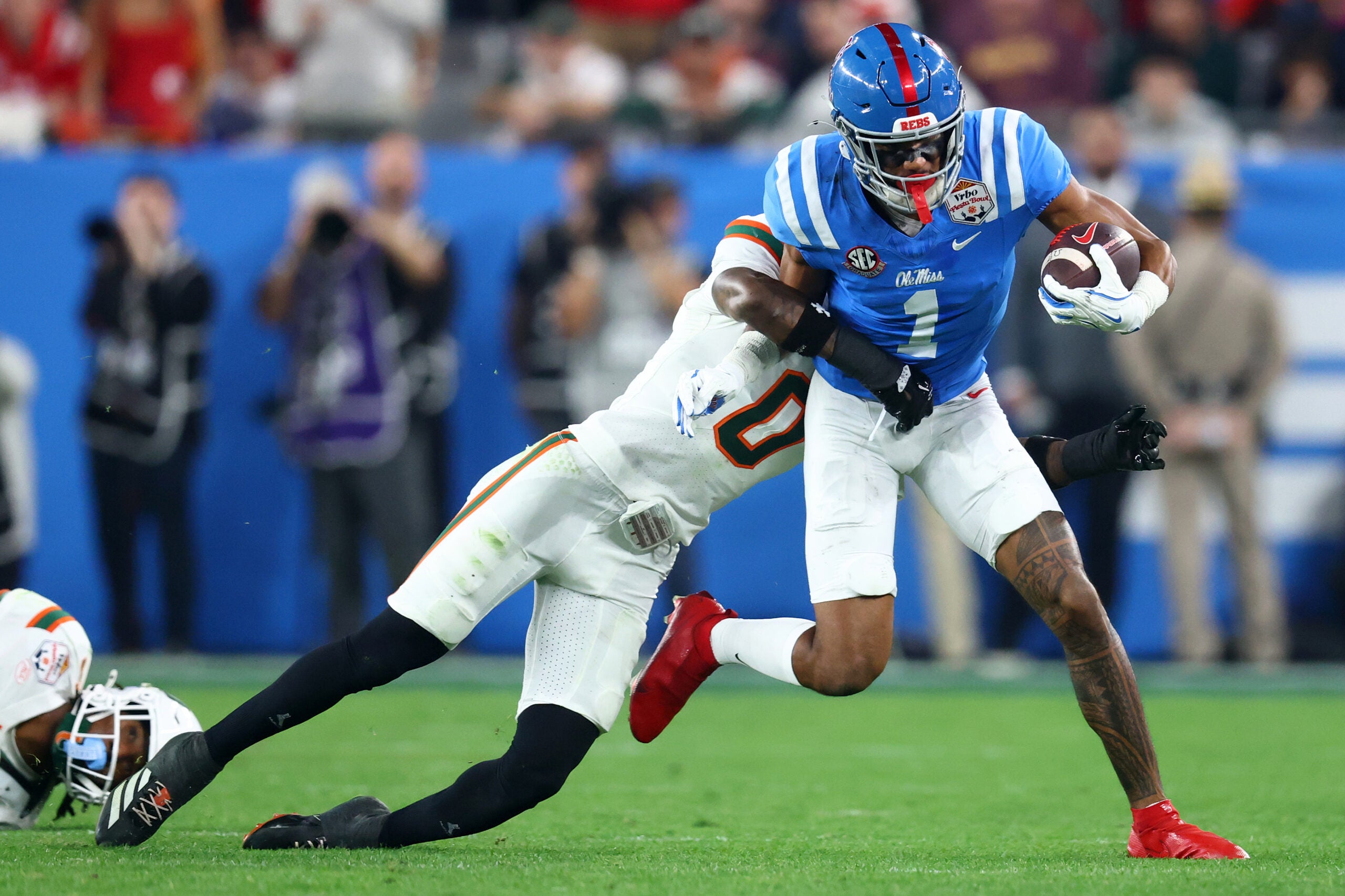 Jan 8, 2026; Glendale, AZ, USA; Mississippi Rebels wide receiver De'Zhaun Stribling (1) makes a catch against Miami Hurricanes defensive back Keionte Scott (0) in the second half during the 2026 Fiesta Bowl and semifinal game of the College Football Playoff at State Farm Stadium.