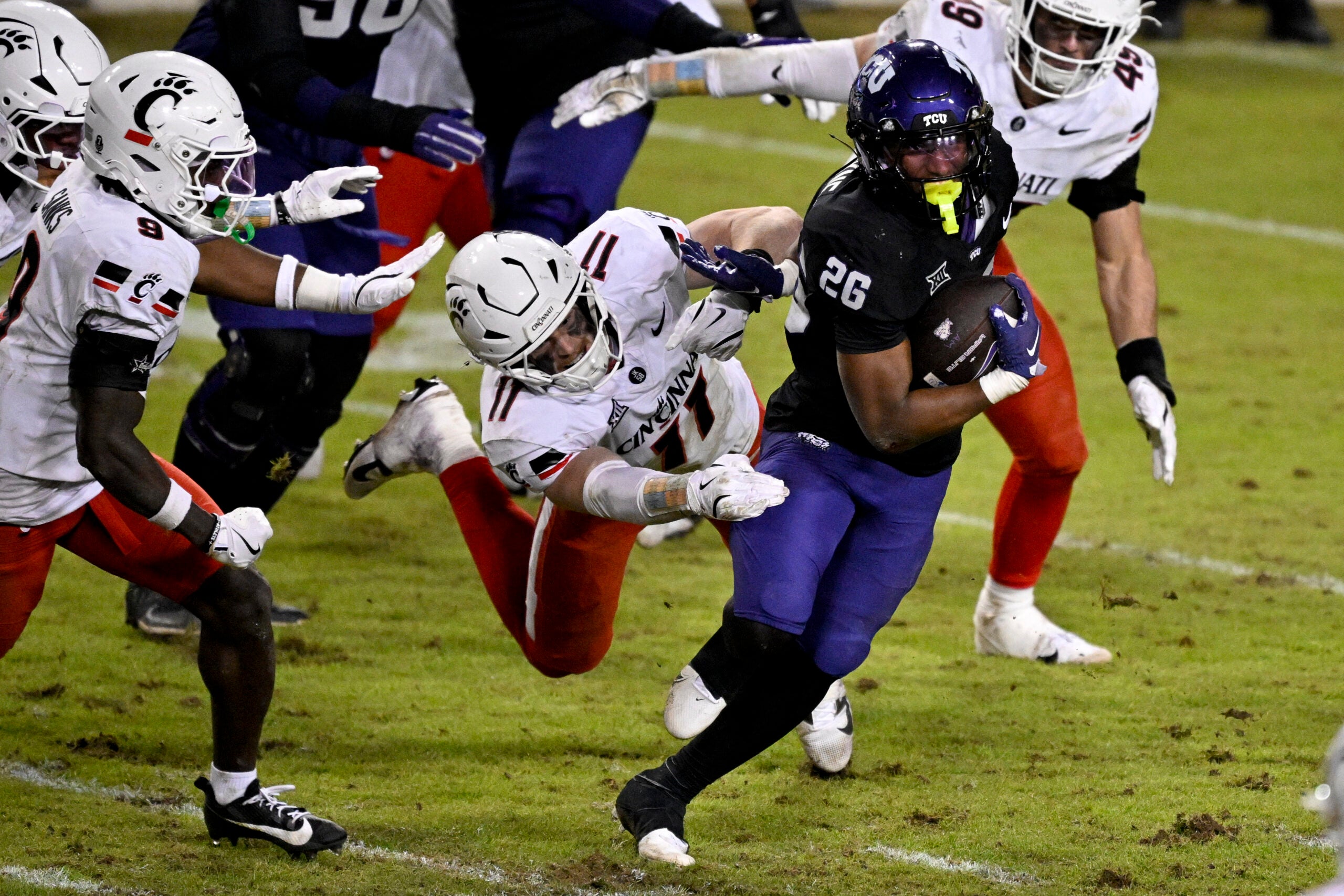 Nov 29, 2025; Fort Worth, Texas, USA; TCU Horned Frogs running back Jeremy Payne (26) eludes the tackle of Cincinnati Bearcats linebacker Jake Golday (11) during the second half at Amon G. Carter Stadium.