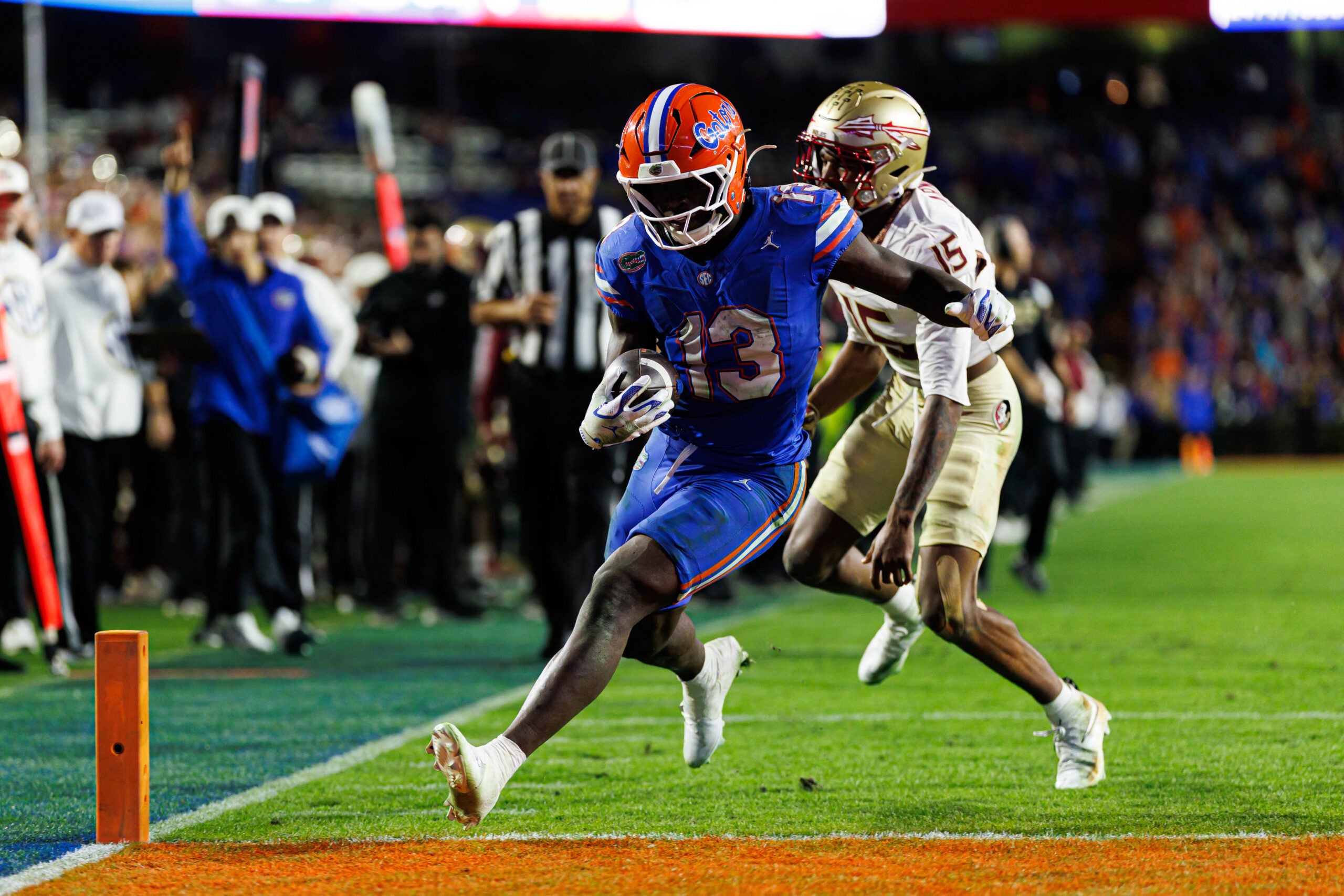 Nov 29, 2025; Gainesville, Florida, USA; Florida Gators running back Jadan Baugh (13) attempts to rush for a touchdown past Florida State Seminoles defensive back Shamar Arnoux (15) during the second half at Ben Hill Griffin Stadium.