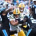 Dec 24, 2023; Charlotte, North Carolina, USA; Green Bay Packers running back AJ Dillon (28) with the ball as Carolina Panthers linebacker Frankie Luvu (49) and cornerback Donte Jackson (26) defend in the third quarter at Bank of America Stadium.