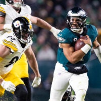Dec 15, 2024; Philadelphia, Pennsylvania, USA; Philadelphia Eagles quarterback Jalen Hurts (1) runs with the ball in front of Pittsburgh Steelers linebacker T.J. Watt (90) during the third quarter at Lincoln Financial Field.