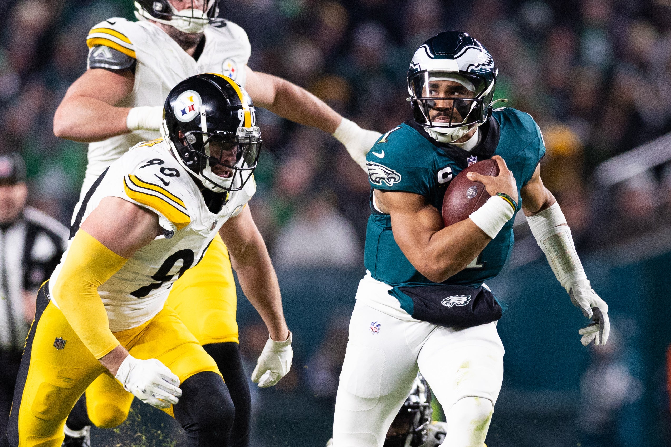 Dec 15, 2024; Philadelphia, Pennsylvania, USA; Philadelphia Eagles quarterback Jalen Hurts (1) runs with the ball in front of Pittsburgh Steelers linebacker T.J. Watt (90) during the third quarter at Lincoln Financial Field.
