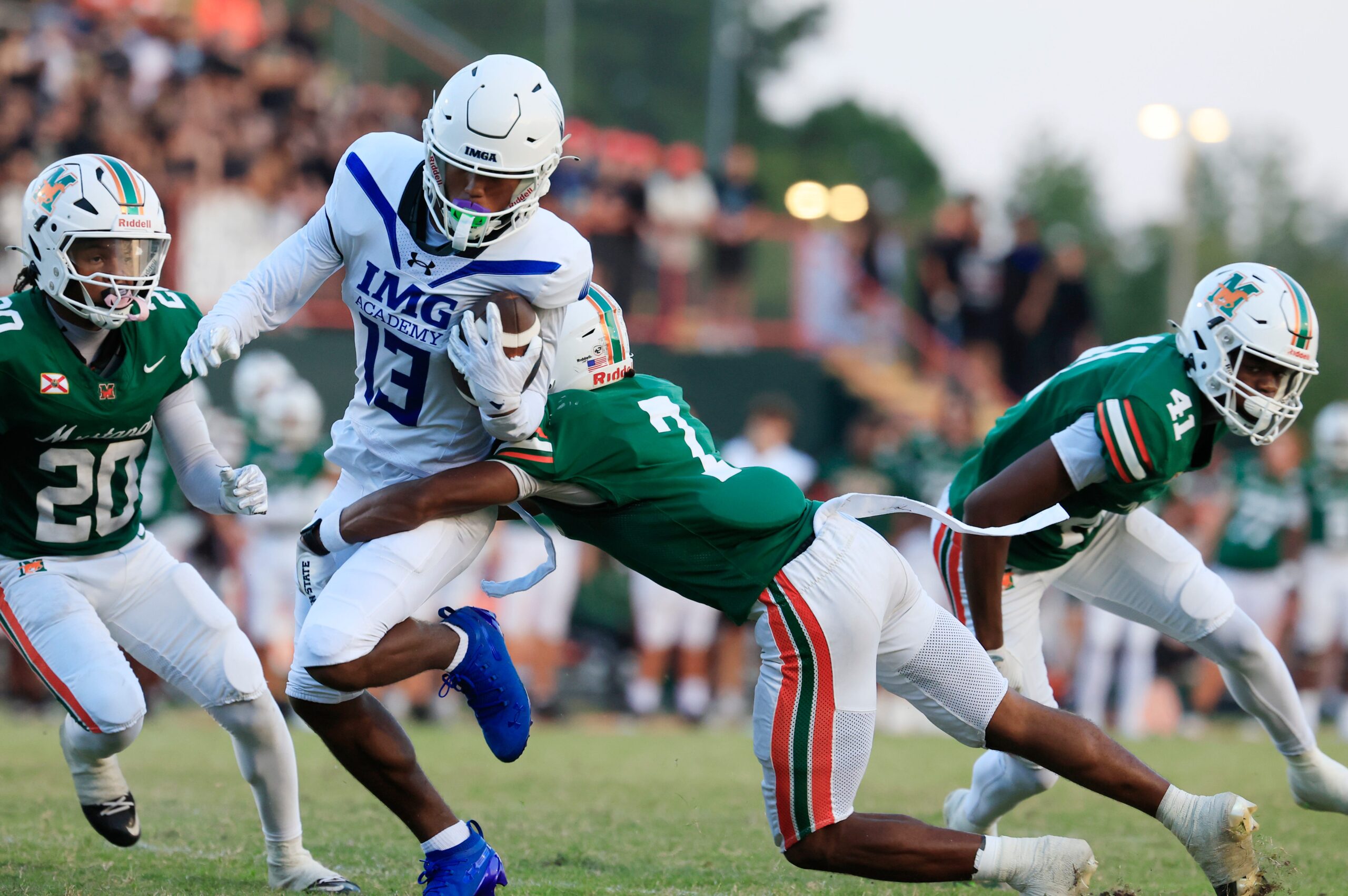 IMG Academy's Osani Gayles (13) rushes for yards against Mandarin's Tamajh Mitchell (7) during the first quarter of a high school football matchup at Mandarin High School, Friday, Sept. 19, 2025, in Jacksonville, Fla. The IMG Academy Ascenders defeated the Mandarin Mustangs 57-7.